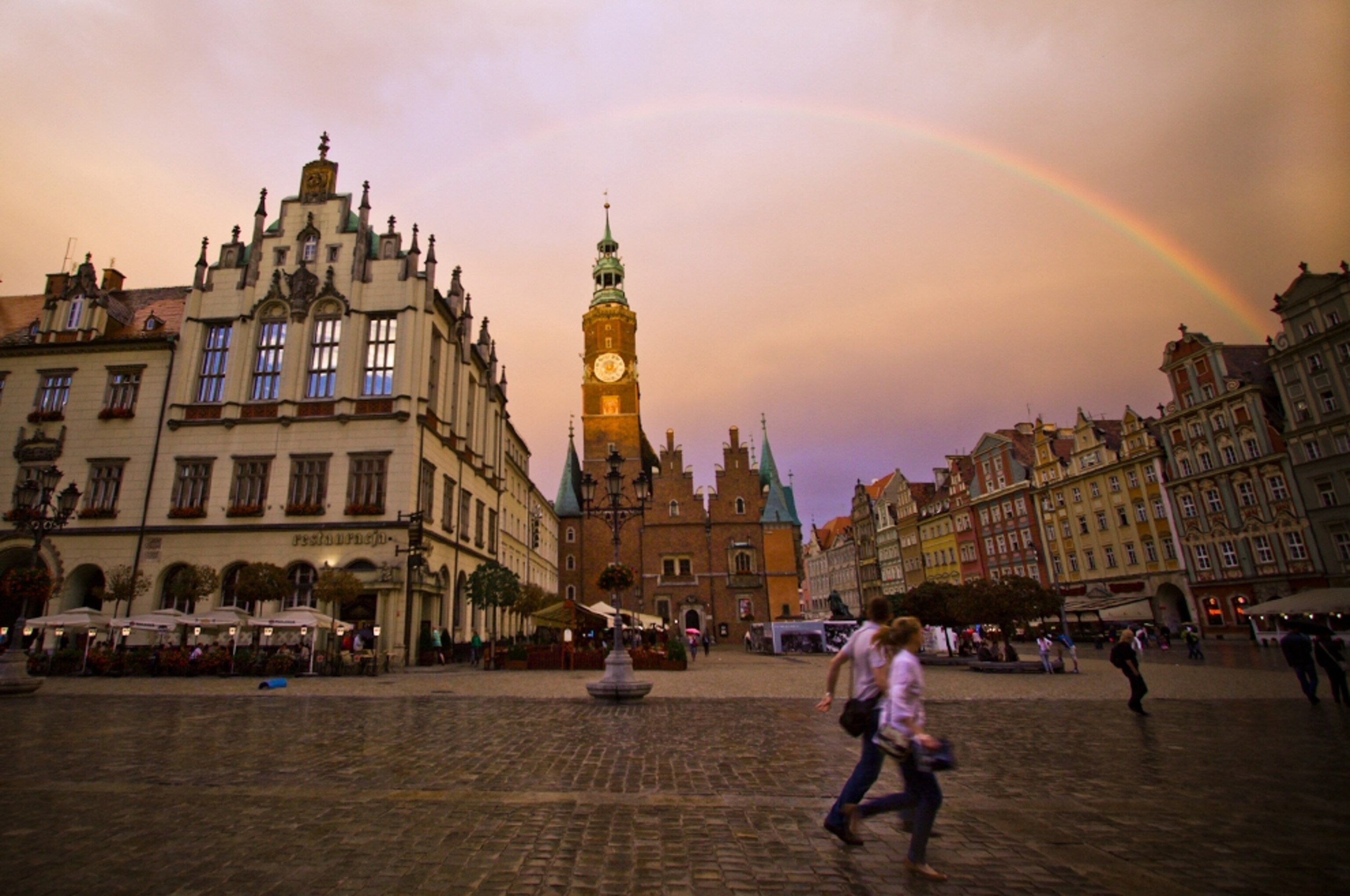 A couple runs through a town square