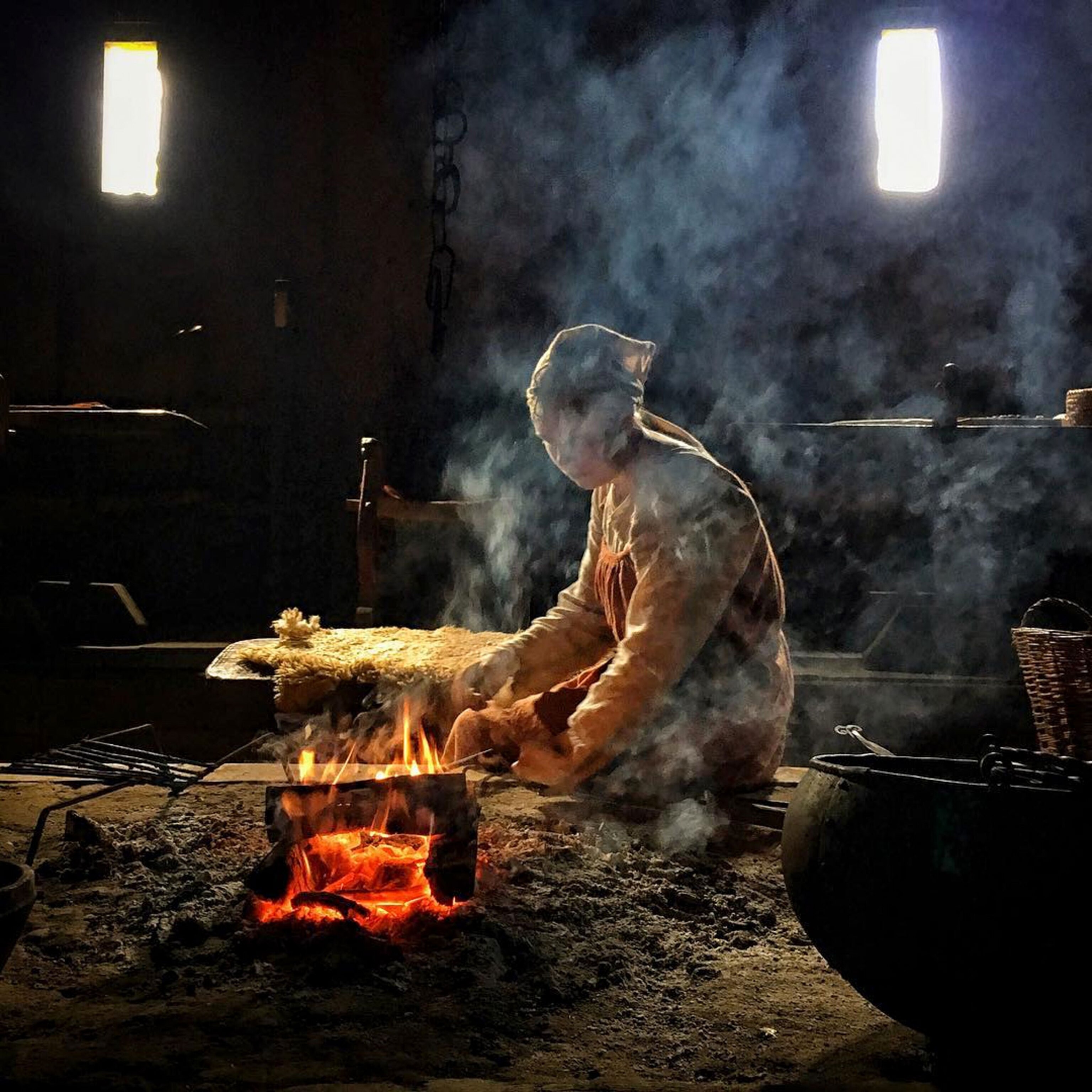 a woman stoking a fire at a Viking festival