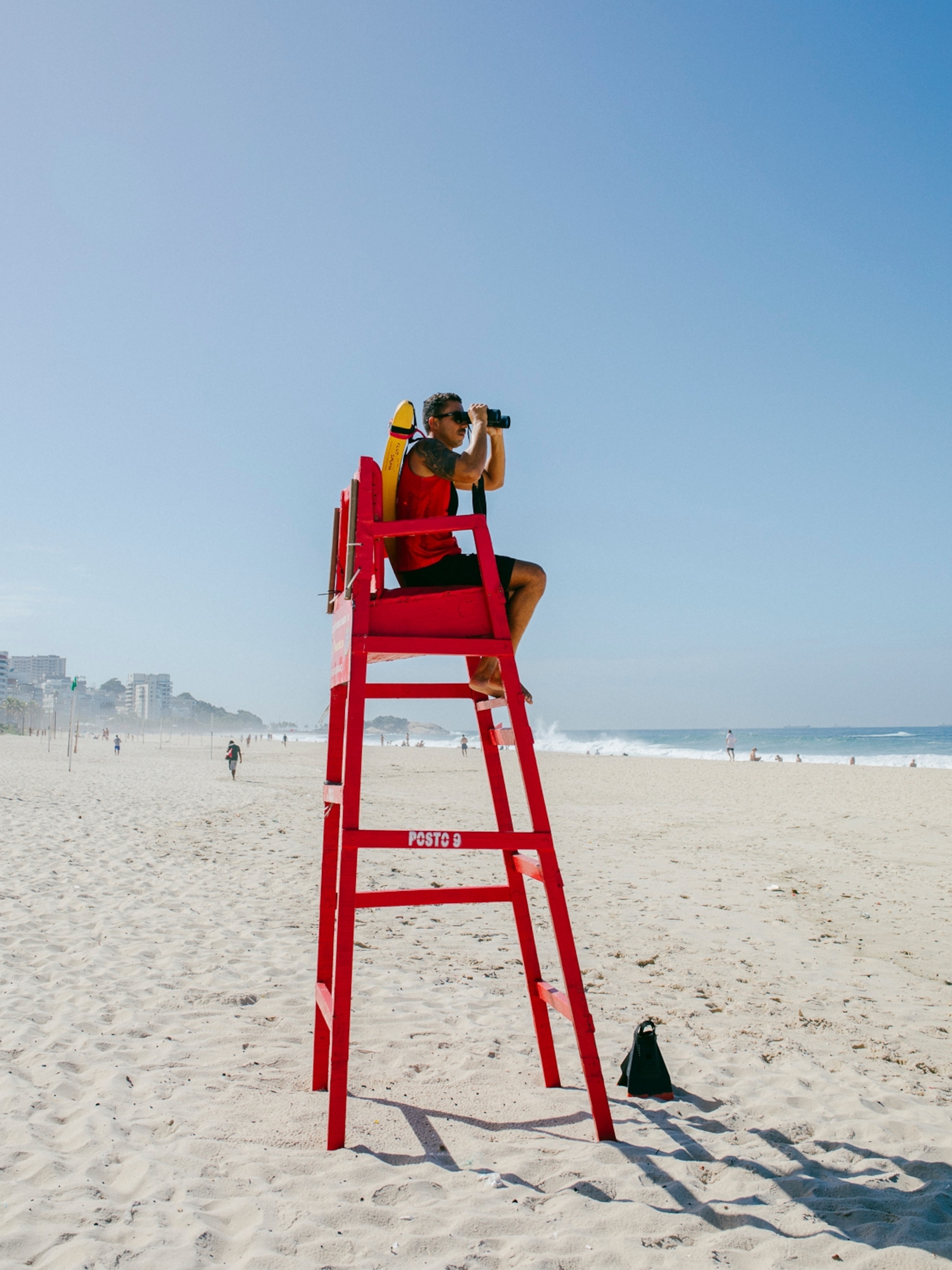 Rio de Janeiro, Brazil: Ipanema Beach, at the beach section „Posto 9“, a lifeguard looks out to sea in the early morning