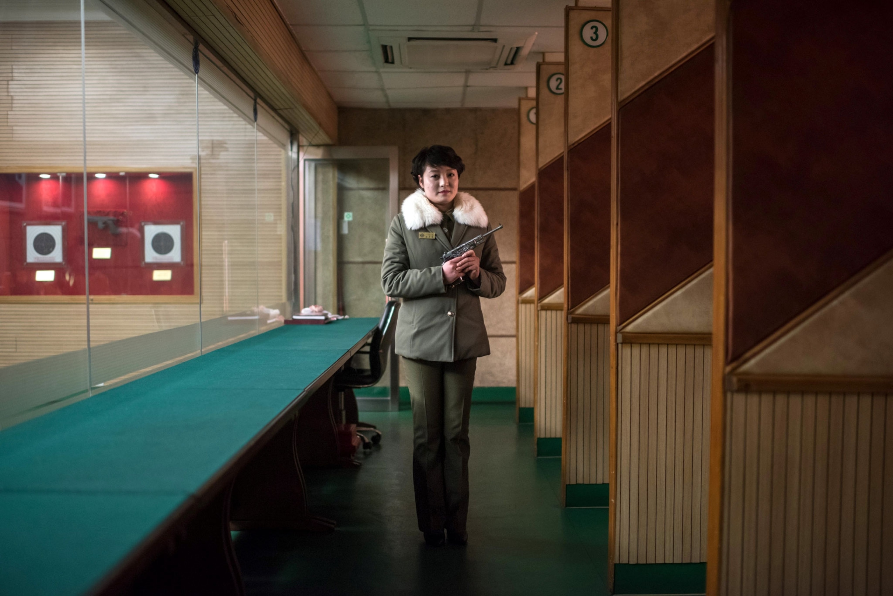 a woman holding a fun at a shooting range in North Korea