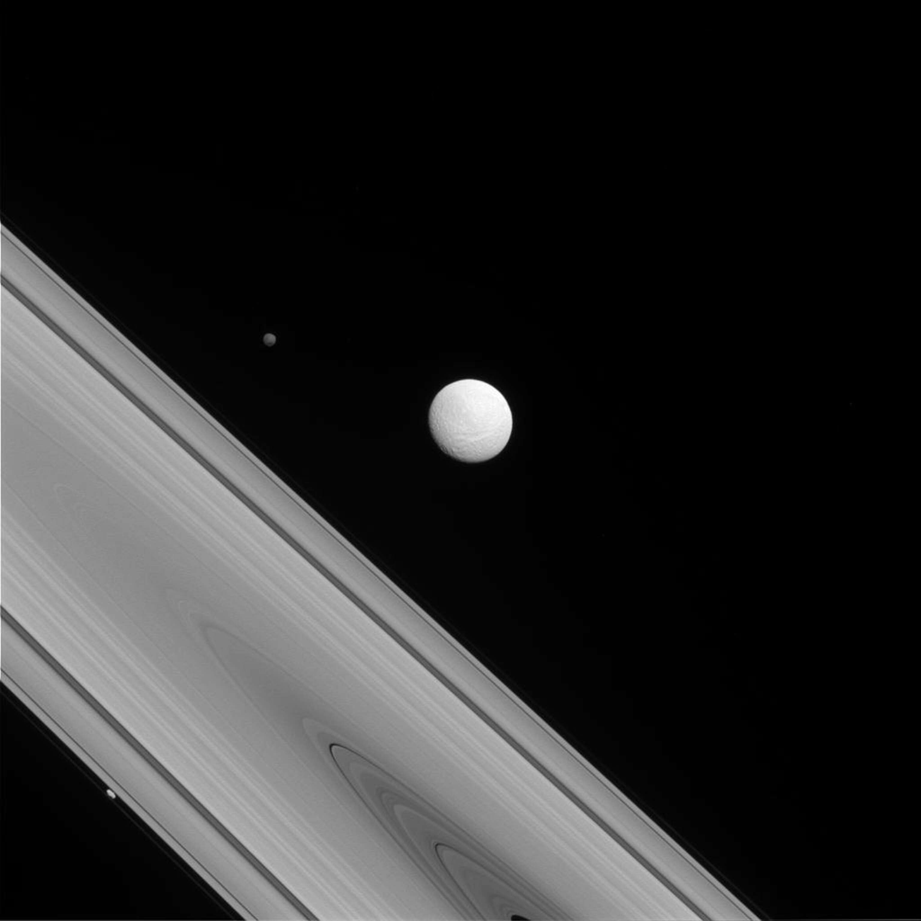 The Cassini spacecraft captures a rare family photo of three of Saturn's moons that couldn't be more different from each other.