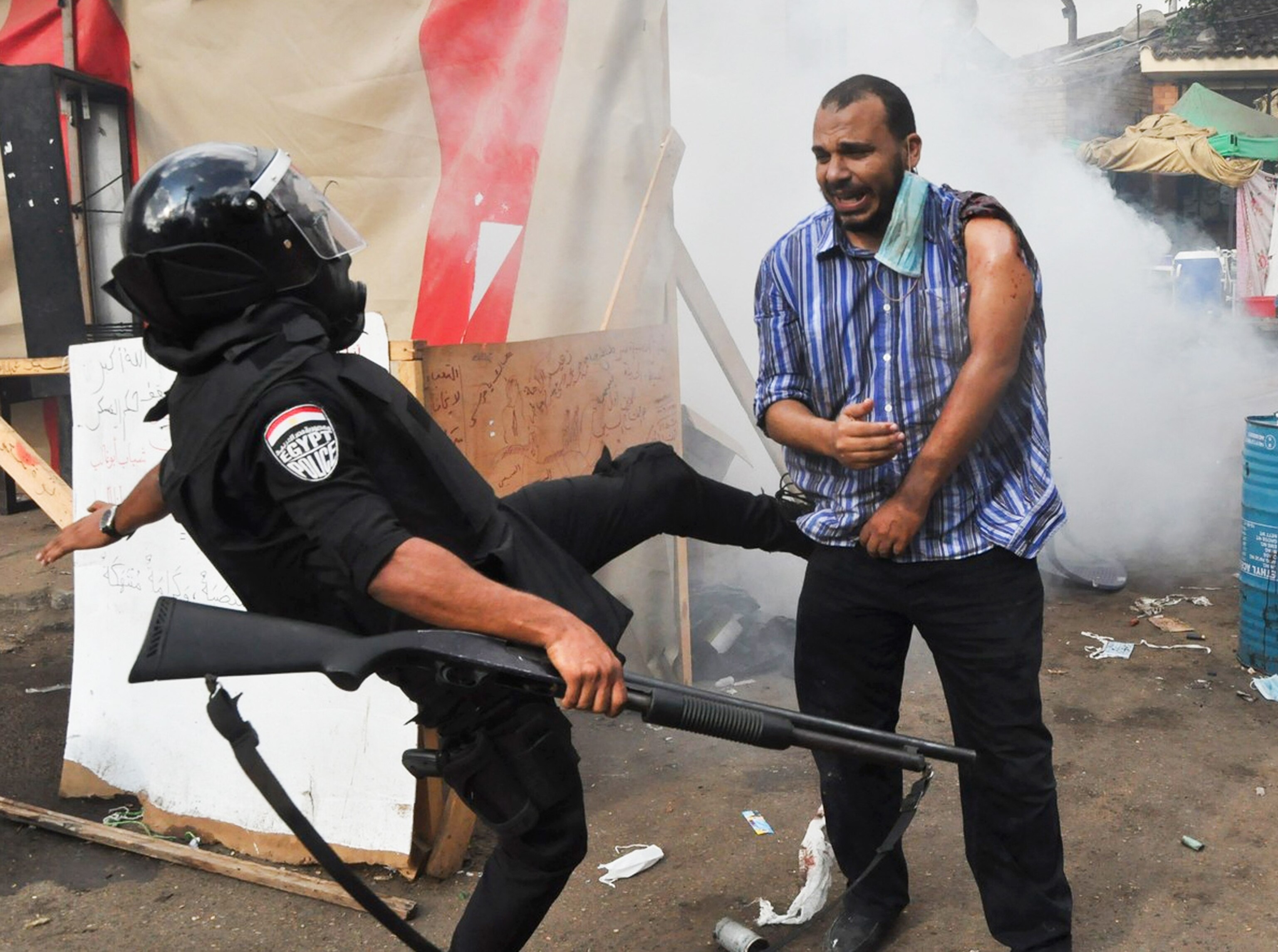 Egyptian security policeman kicks a protester.