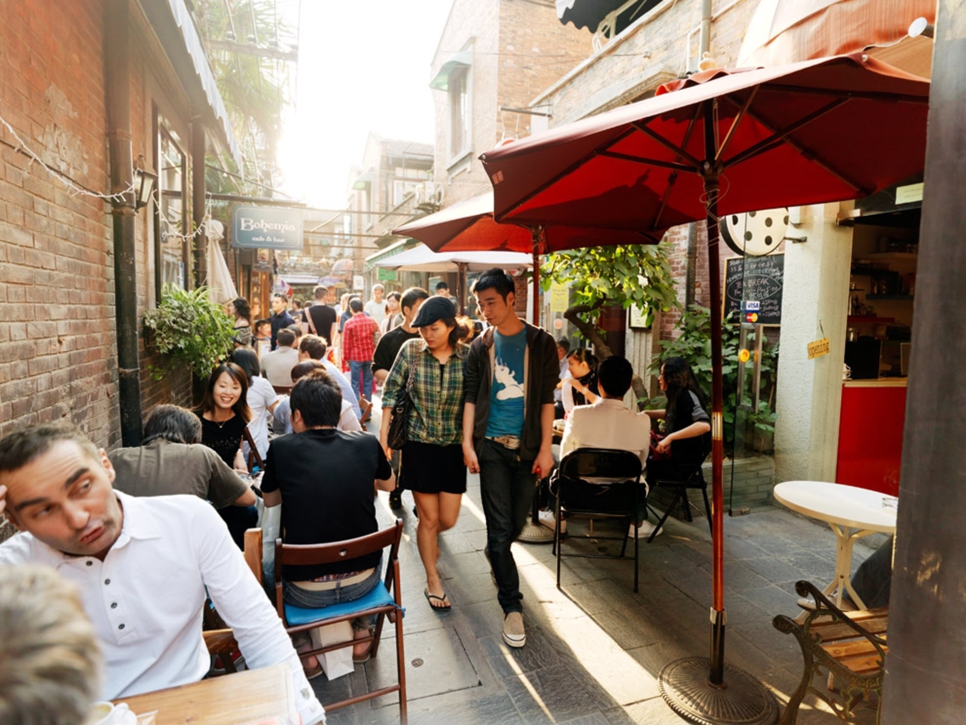 Young couple strolling through outdoor dining tables