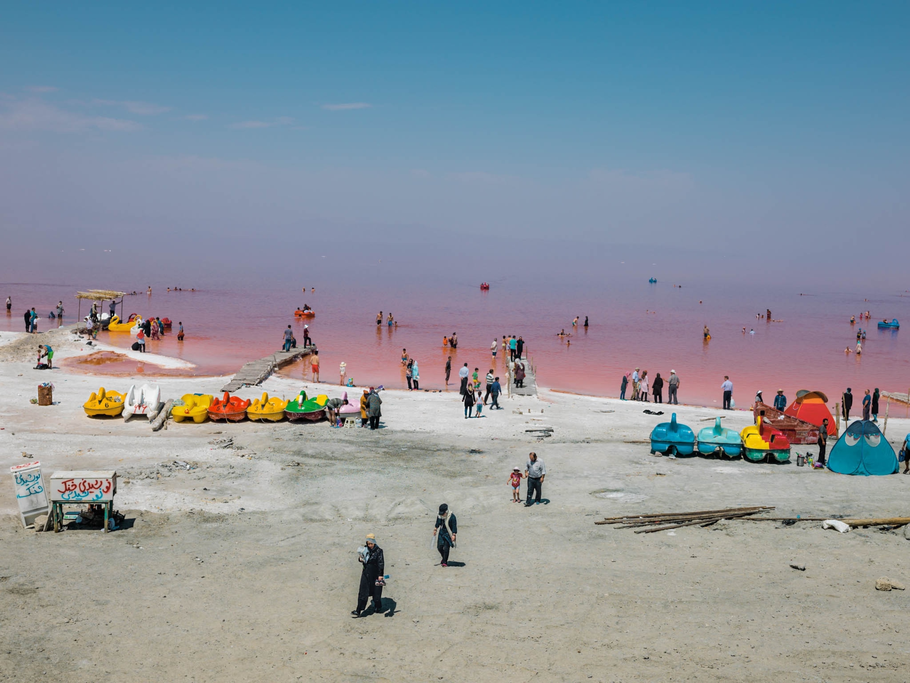 visitors and paddleboats on the shores of Lake Urmia, Iran
