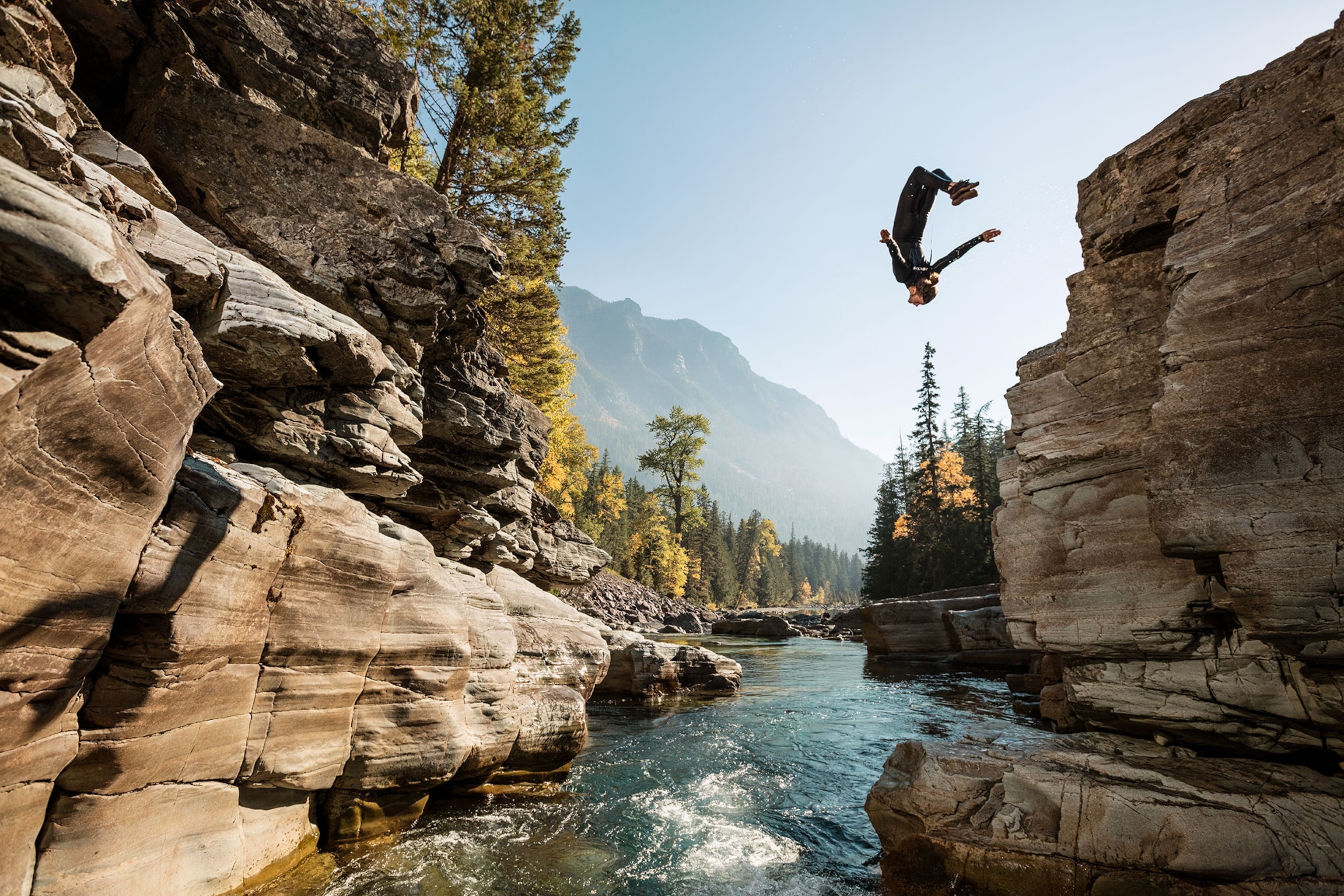 a man doing a back flip off of a cliff