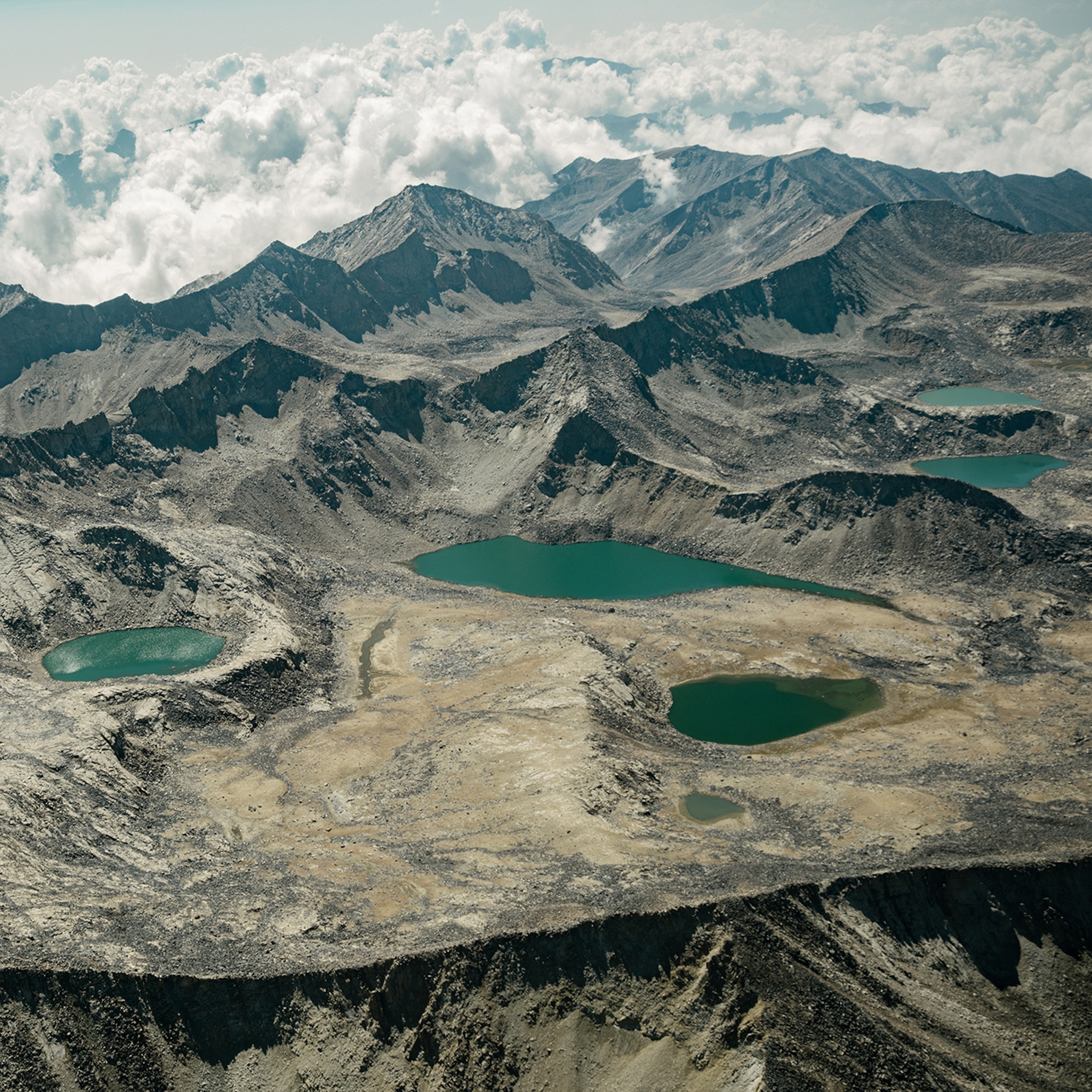 An aerial view of mountains with several small bodies of water.