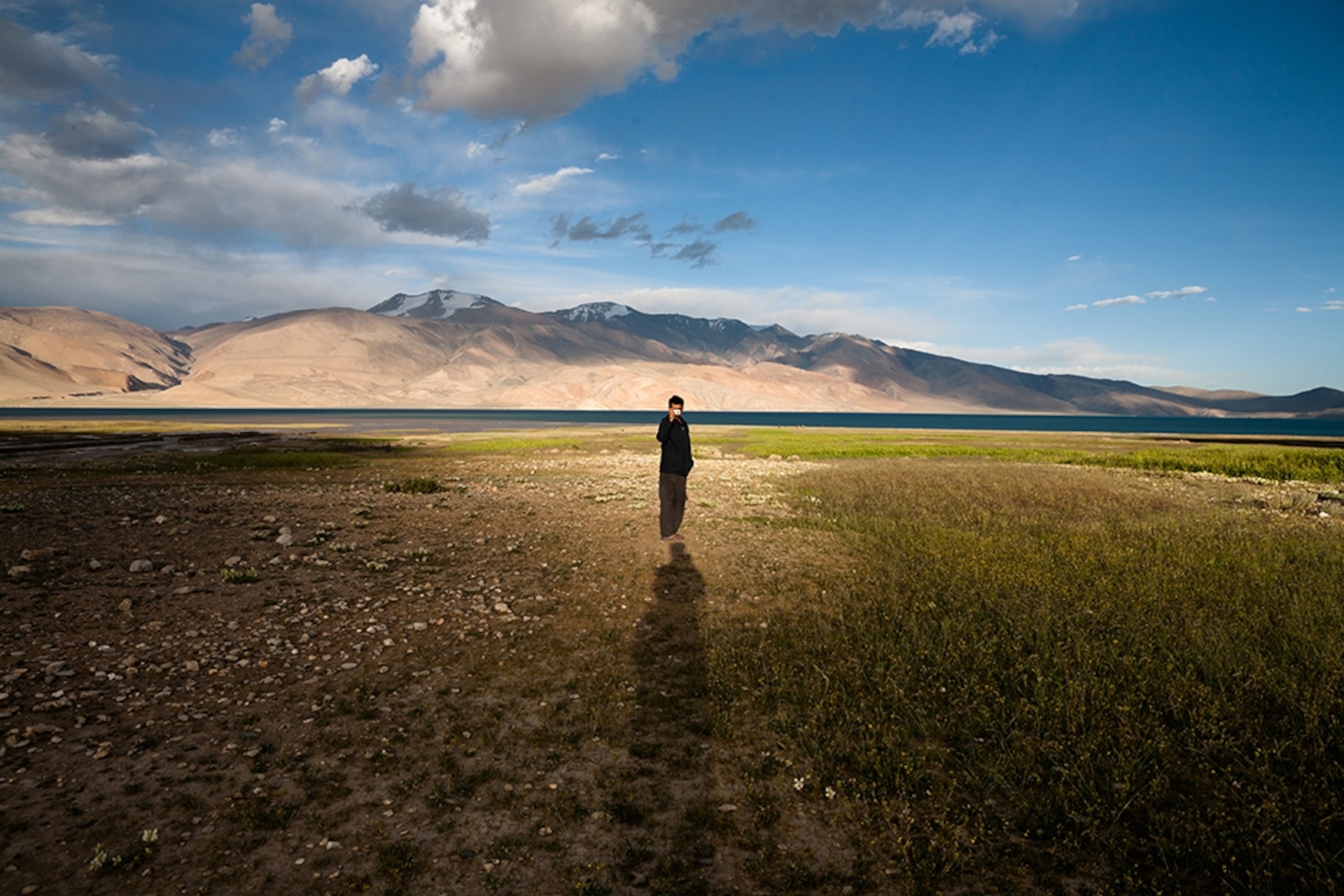 a man standing near Tso Moriri Lake, India