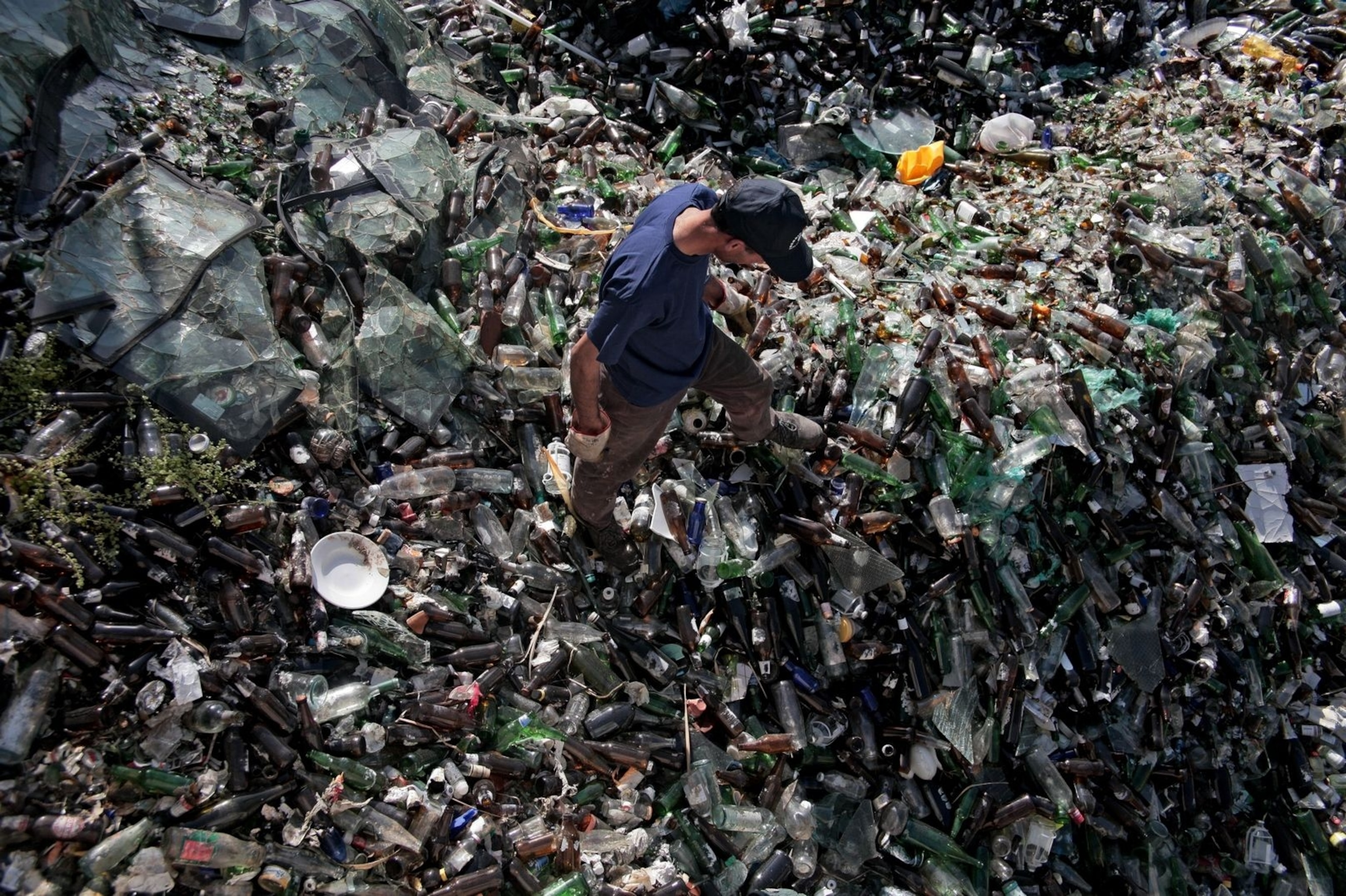 A man picks through bottles bound for recycling