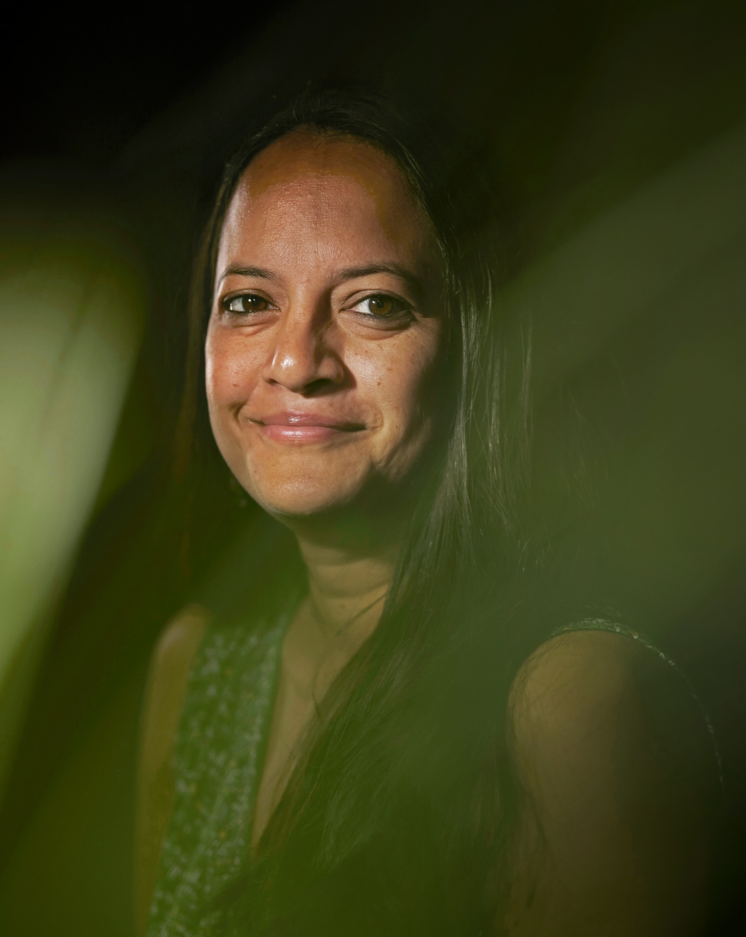 Portrait of young woman smiling on the low-lit background.