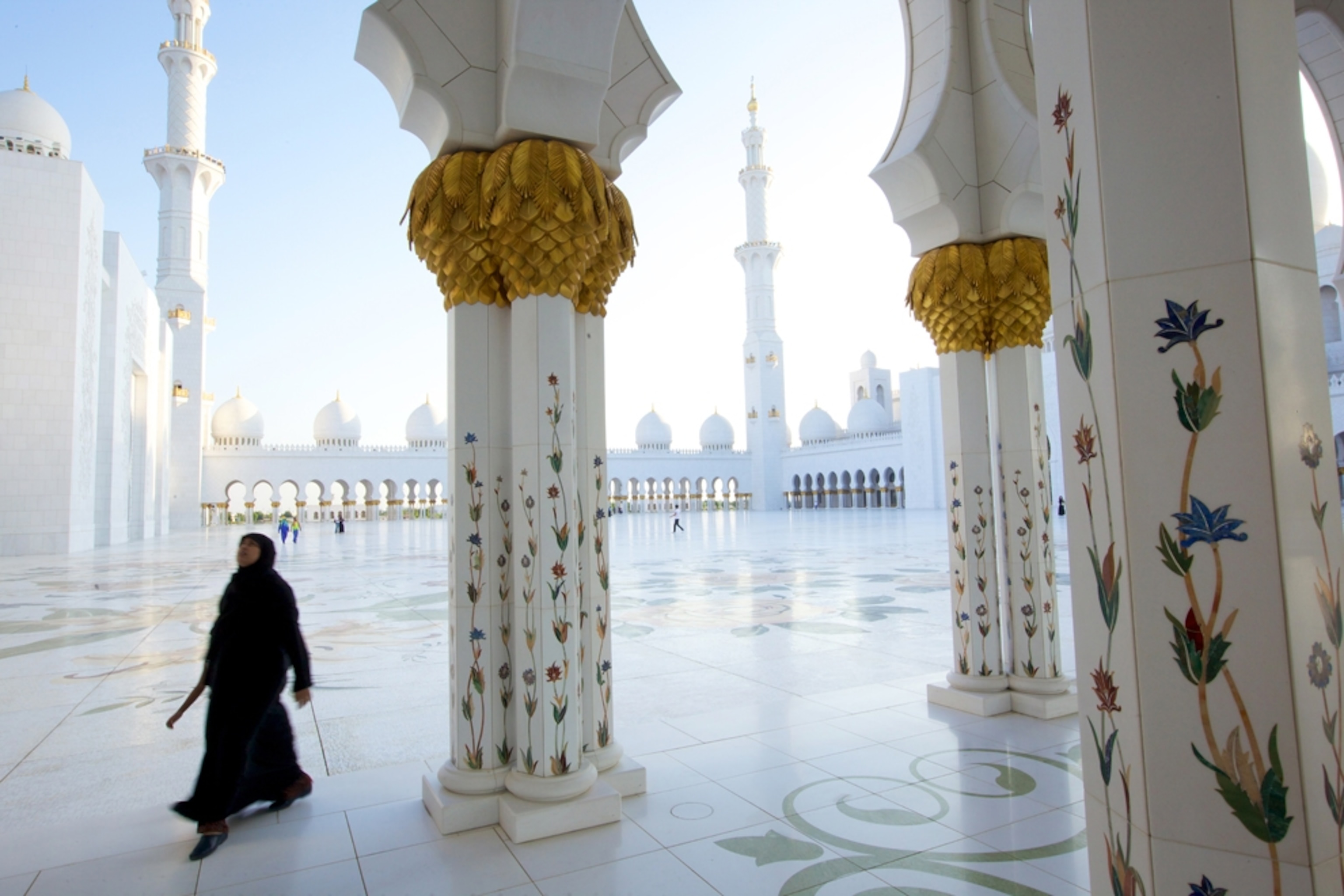 a woman walking through a mosque in Abu Dhabi