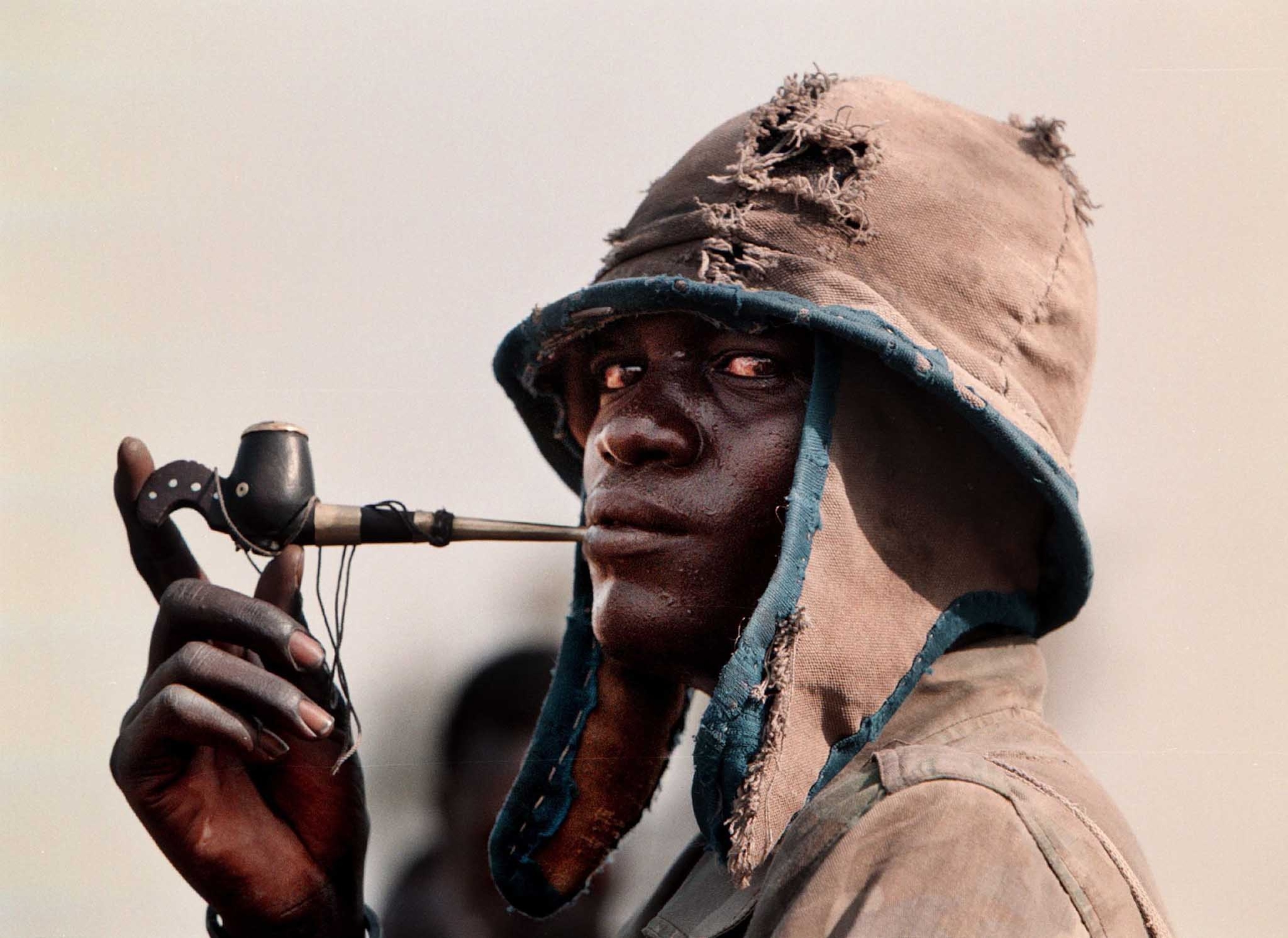 Madut Atien, an SPLA rebel, smokes a pipe after arriving to protect the peace village at Wunlit, Sudan.