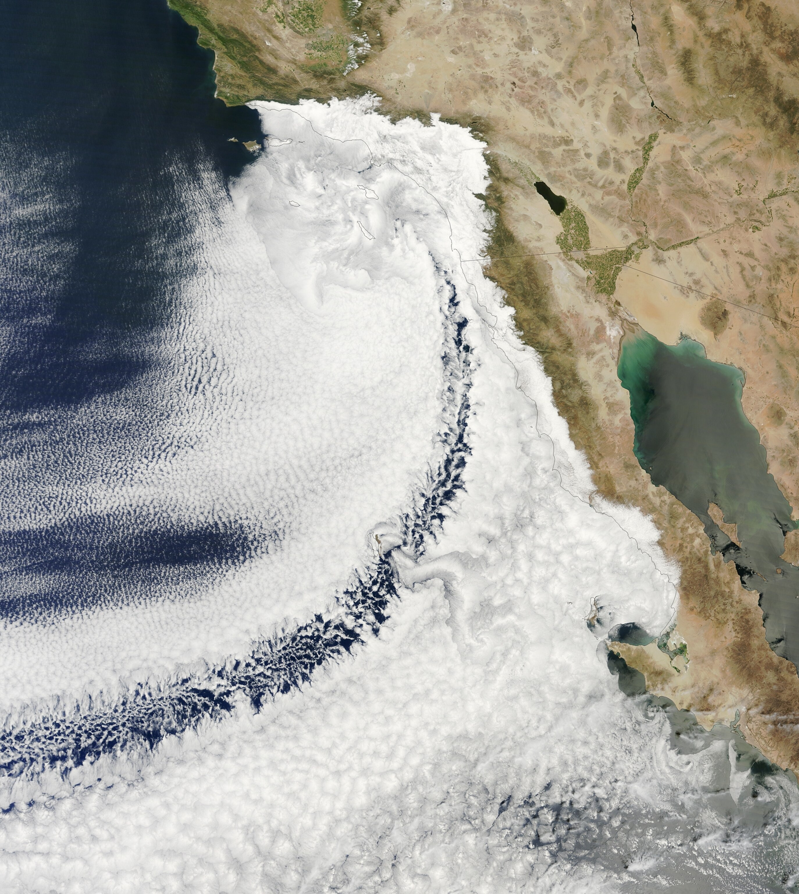 an arc of clouds over the eastern Pacific Ocean off the coast of California and Mexico