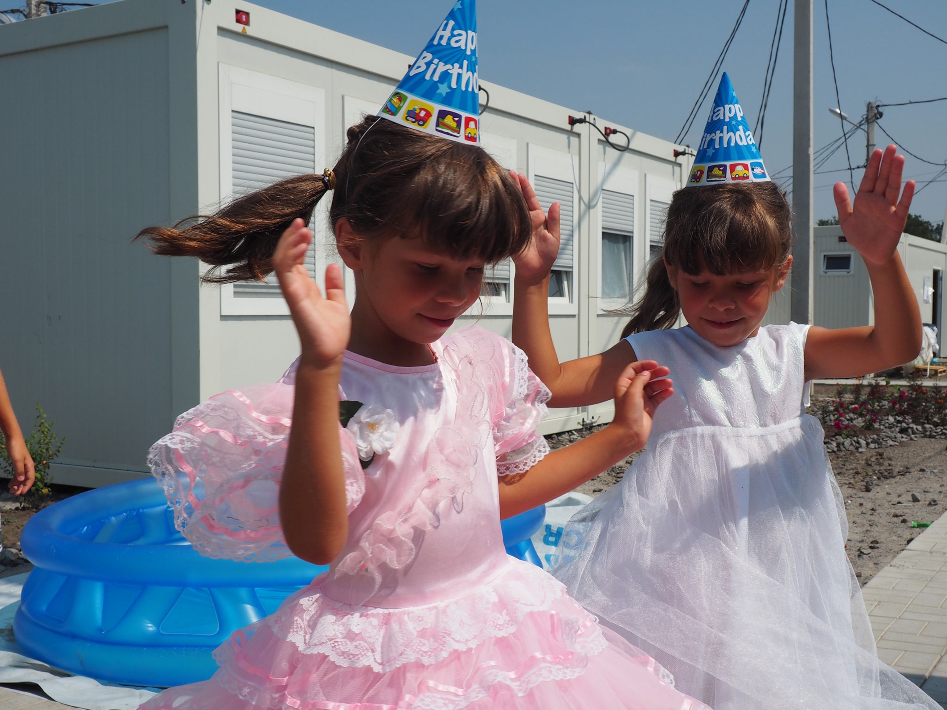 Two young girls celebrate a birthday party at a camp for IDPs in Ukraine