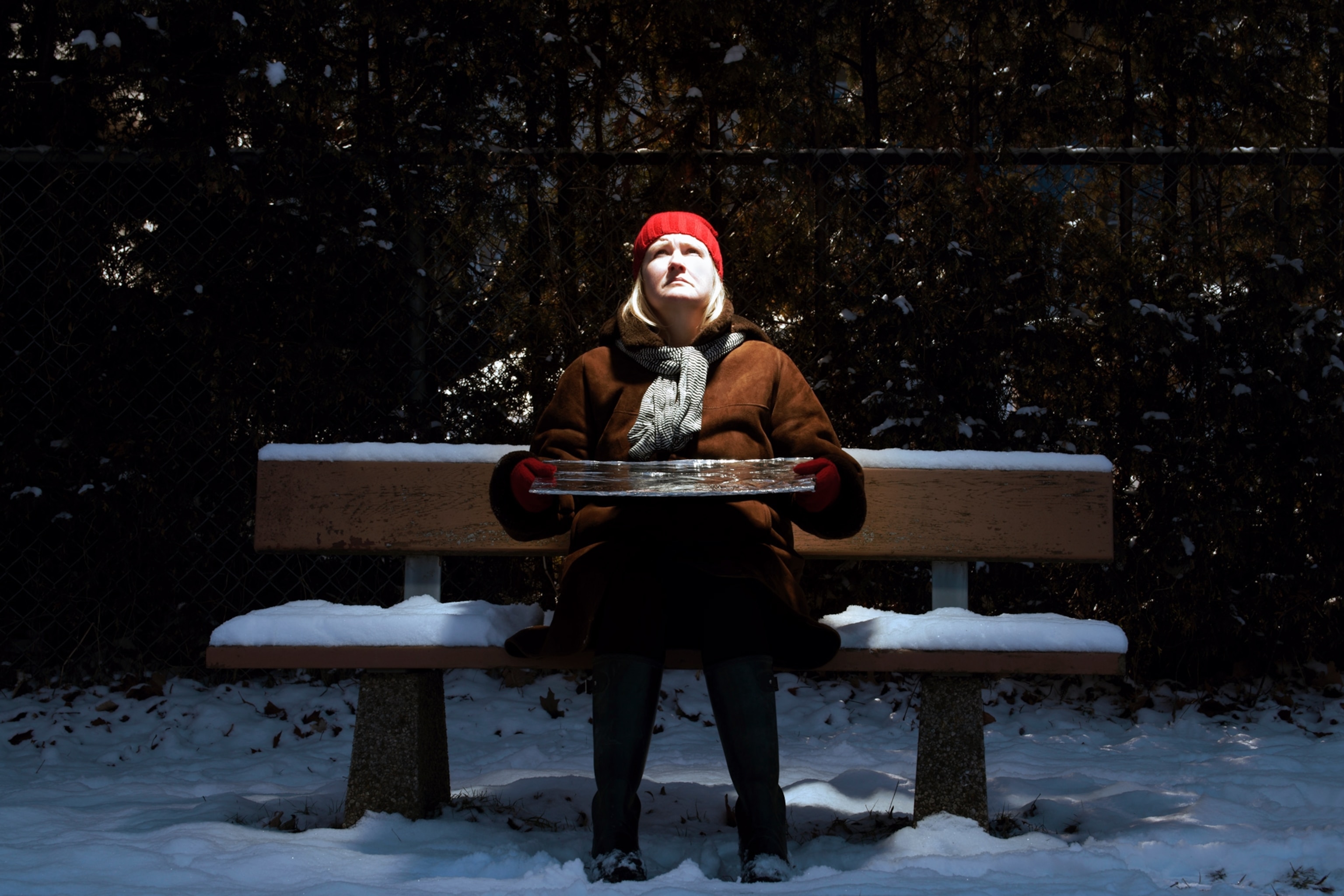 Photo of woman on bench with reflected light on her face