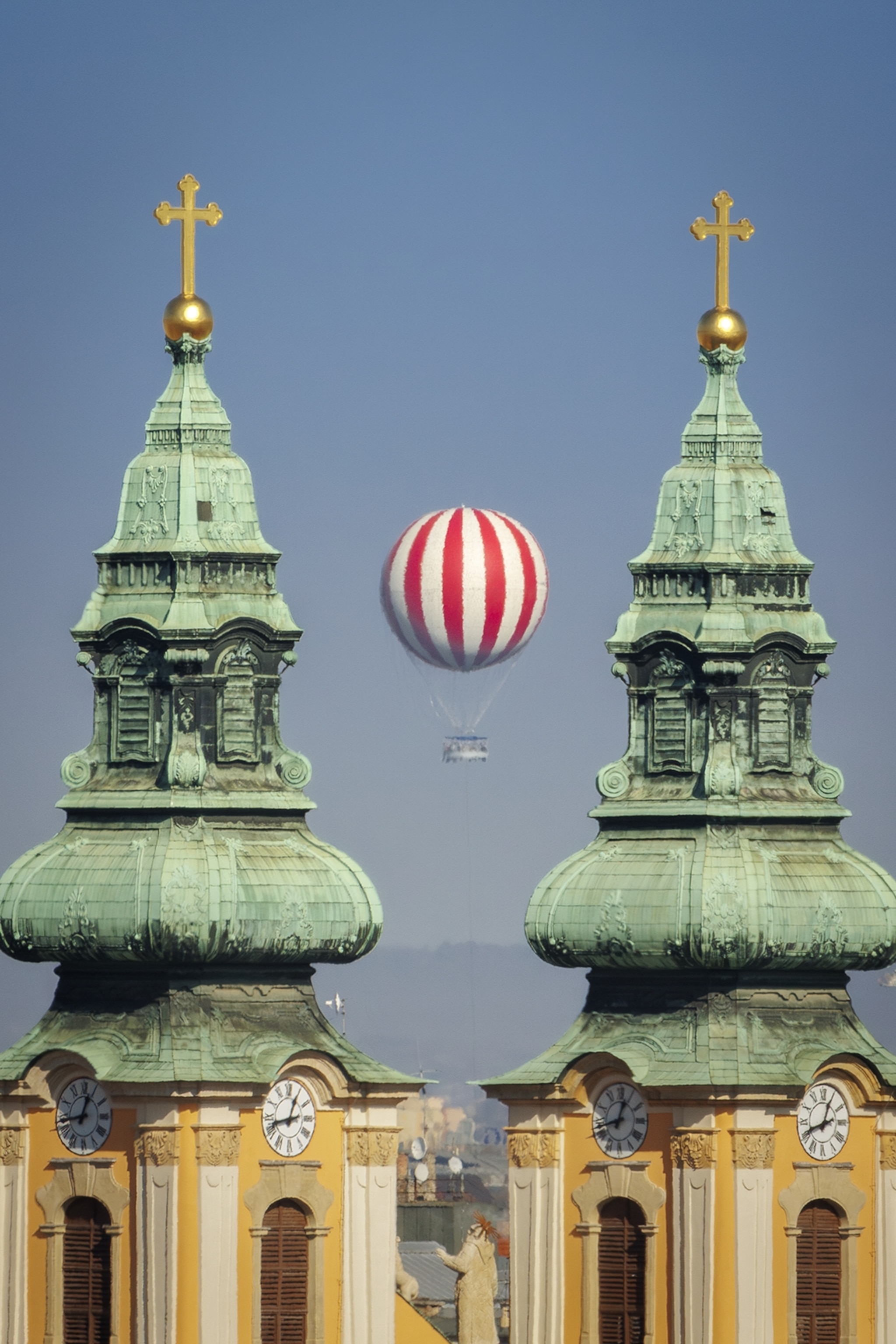 Twin towers of a church with a hot air ballon in the middle.