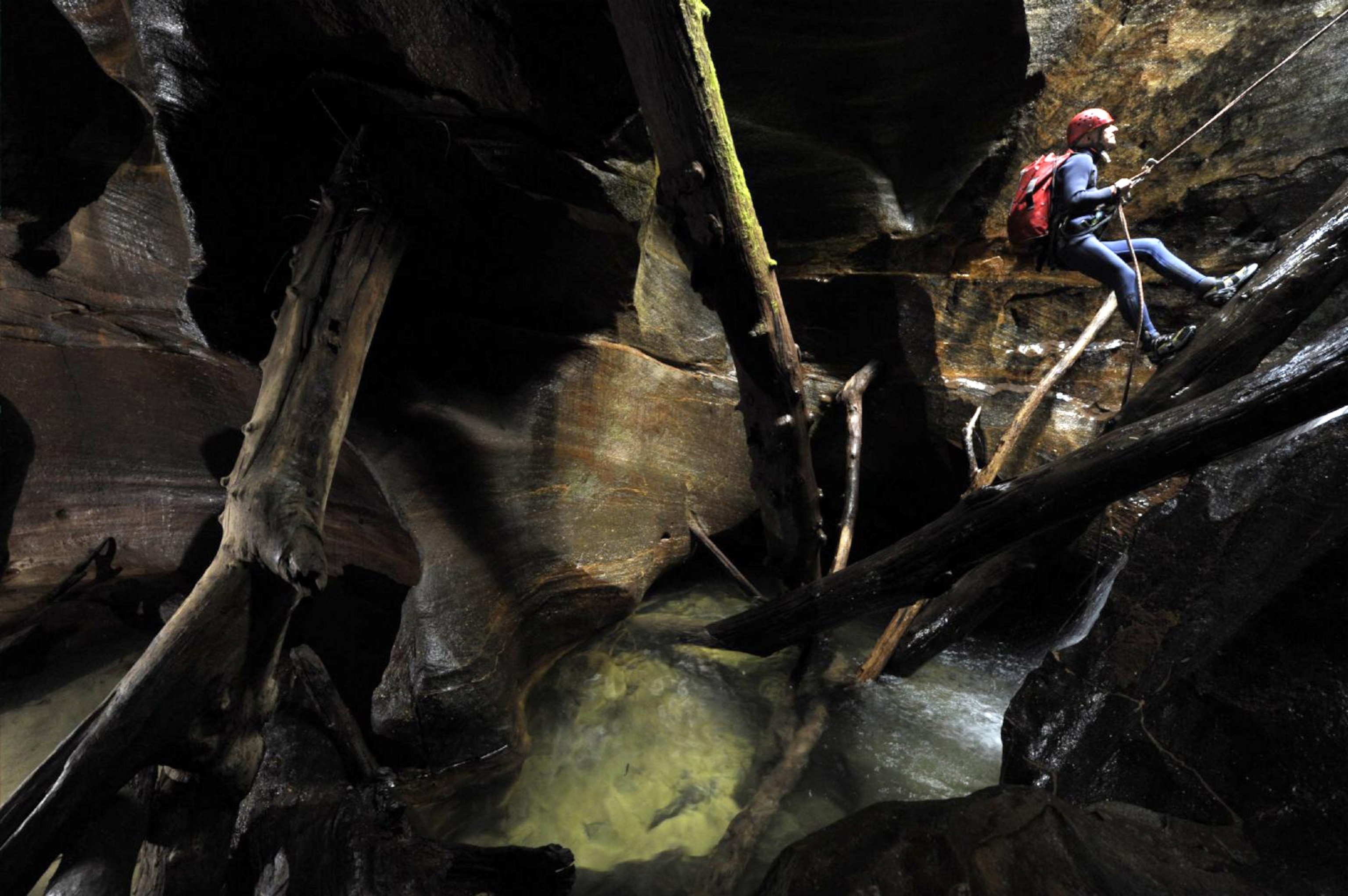 a canyoneer descending into Hole-in-the-Wall Canyon in Blue Mountains National Park