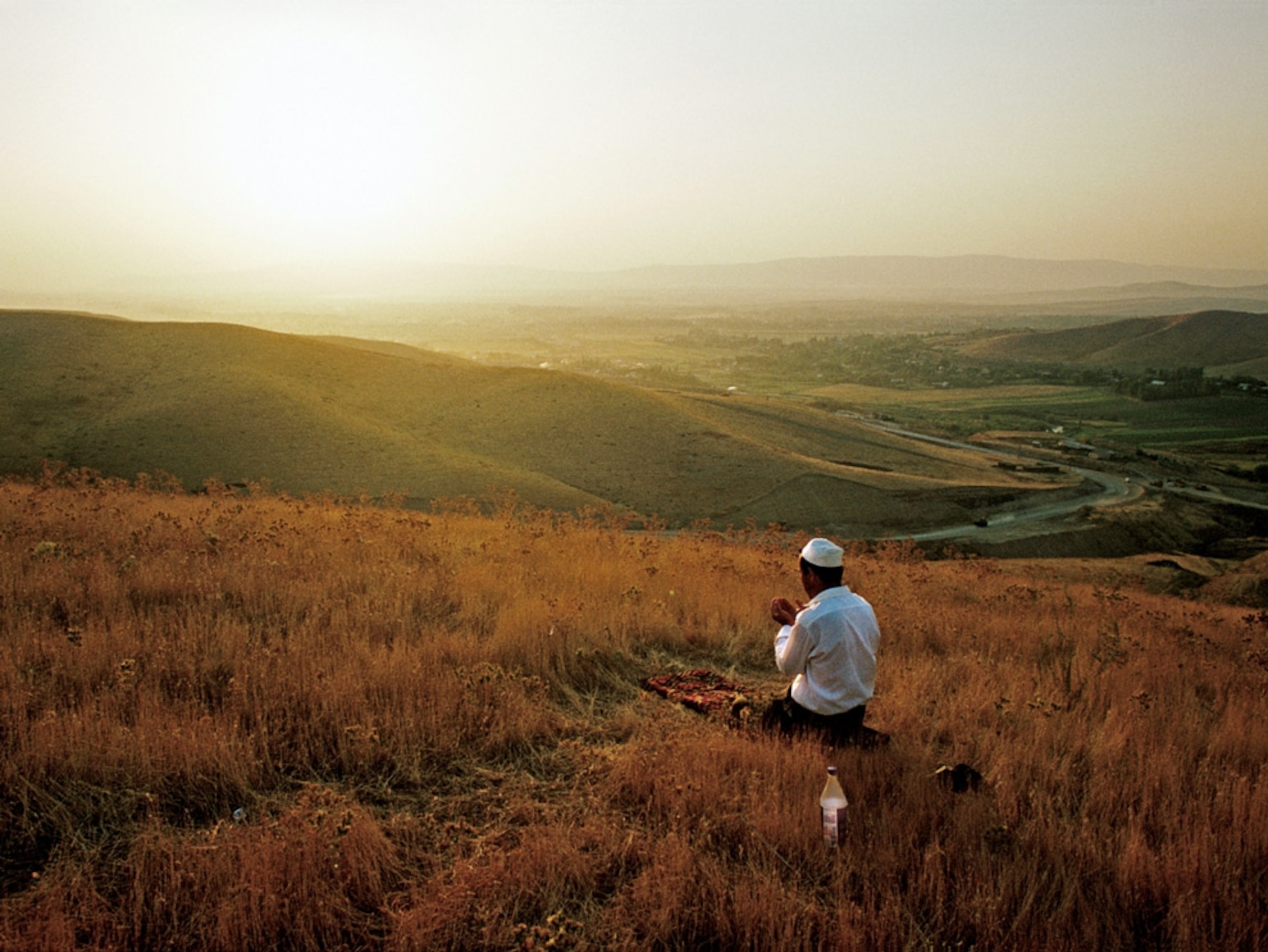 A man praying on a hillside