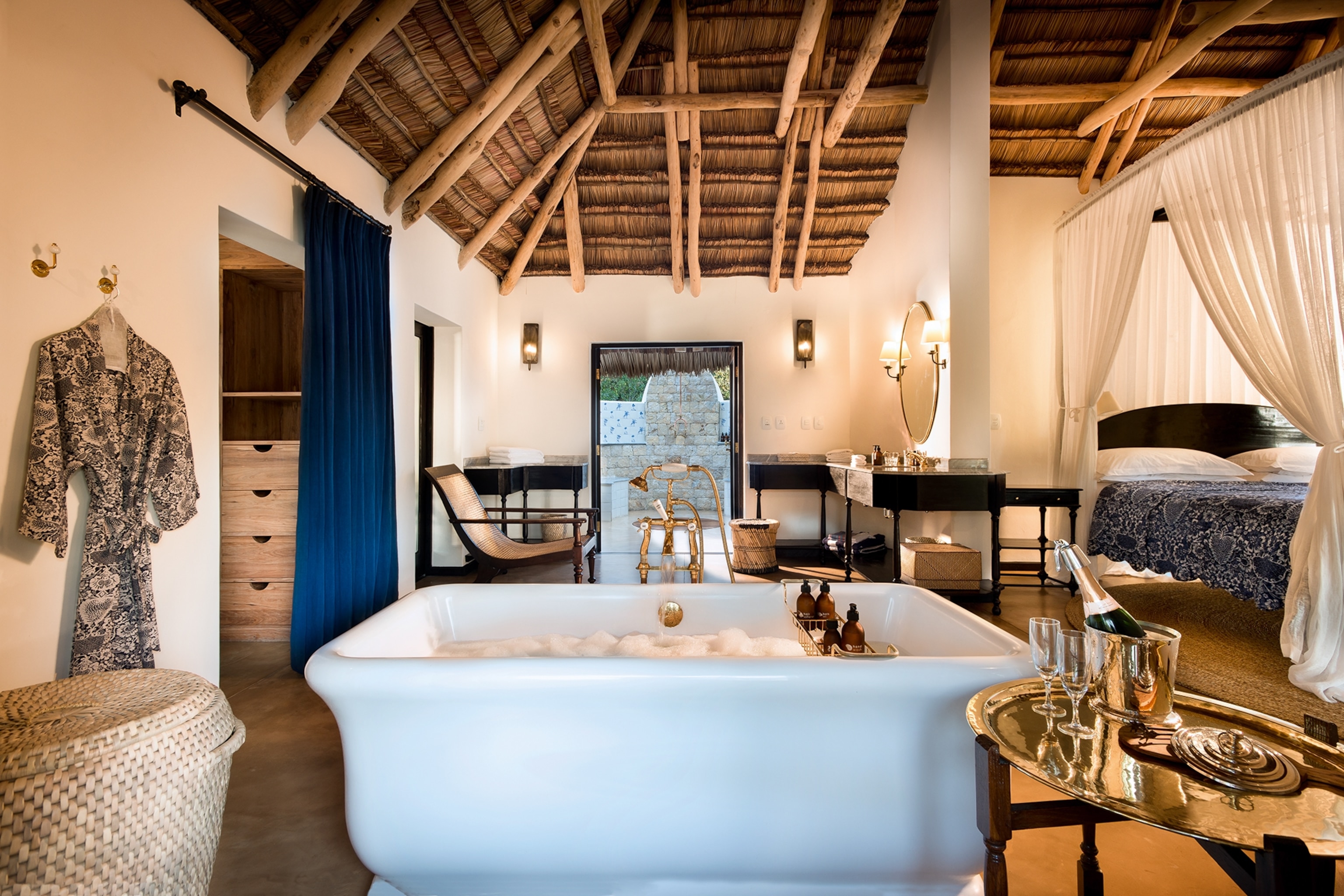 The interiors of a bungalow hotel bedroom with a bamboo ceiling.