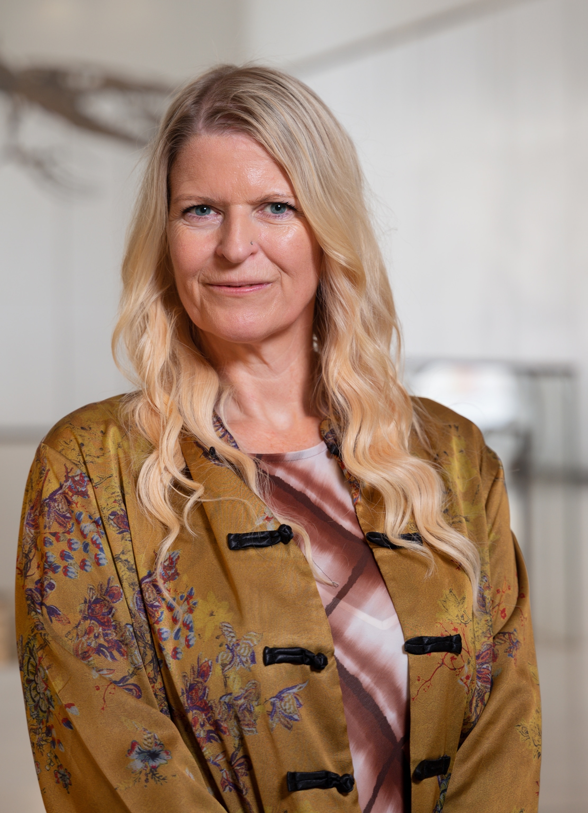 Portrait of a person with long, blonde hair wearing a yellow top.