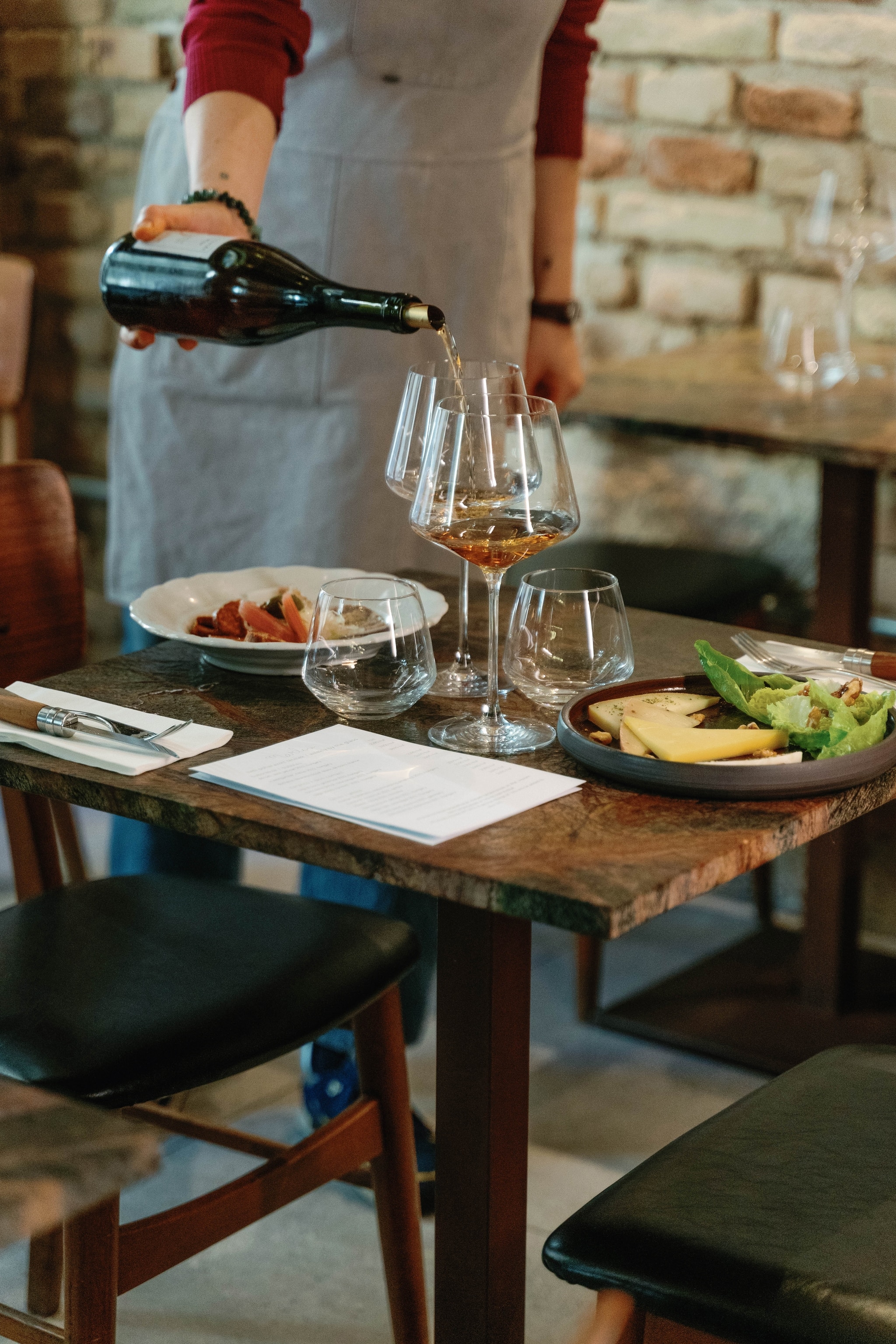Table of food with a waitress pouring wine