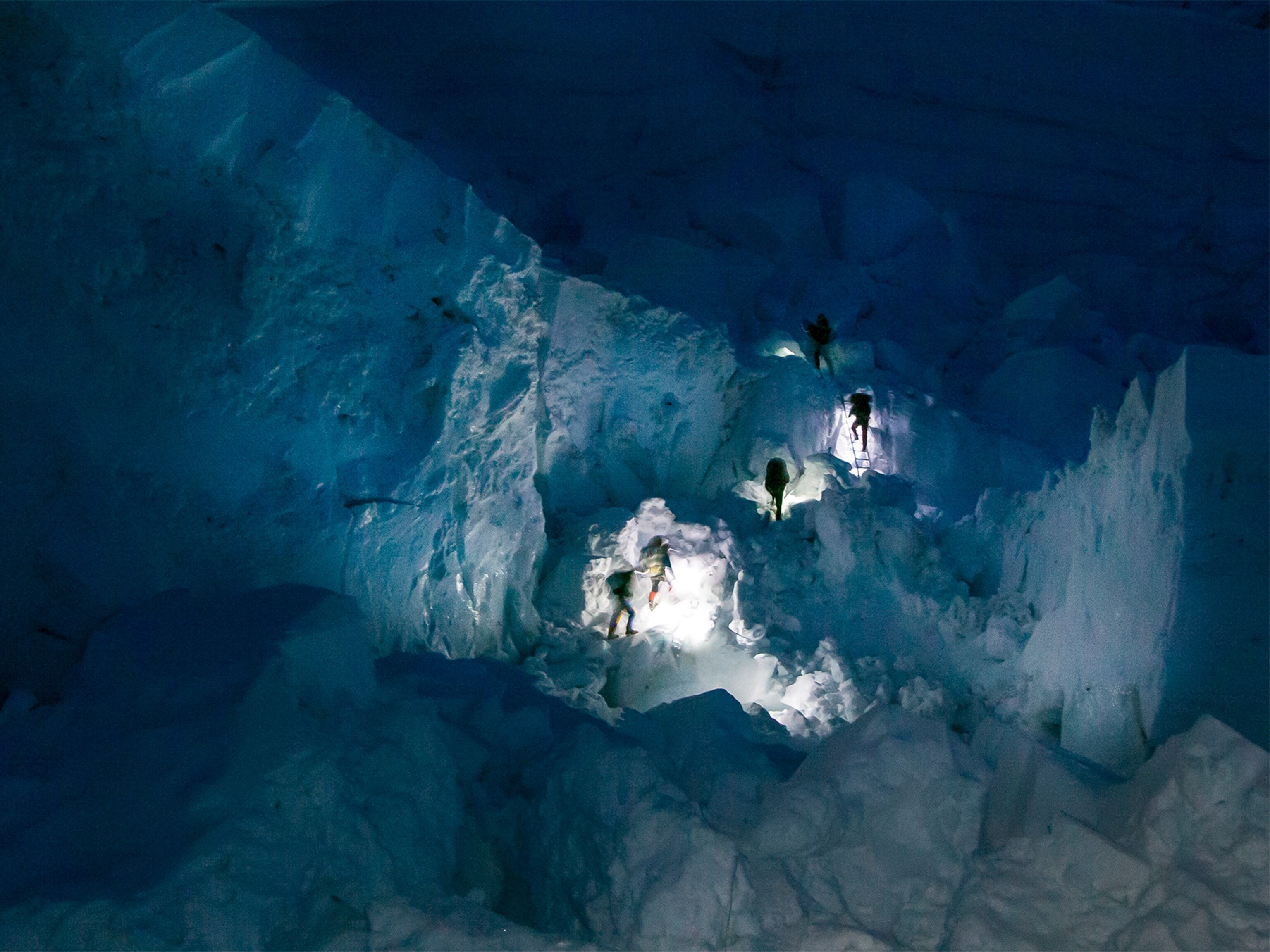 an expedition member standing in front of the Himalayan range.