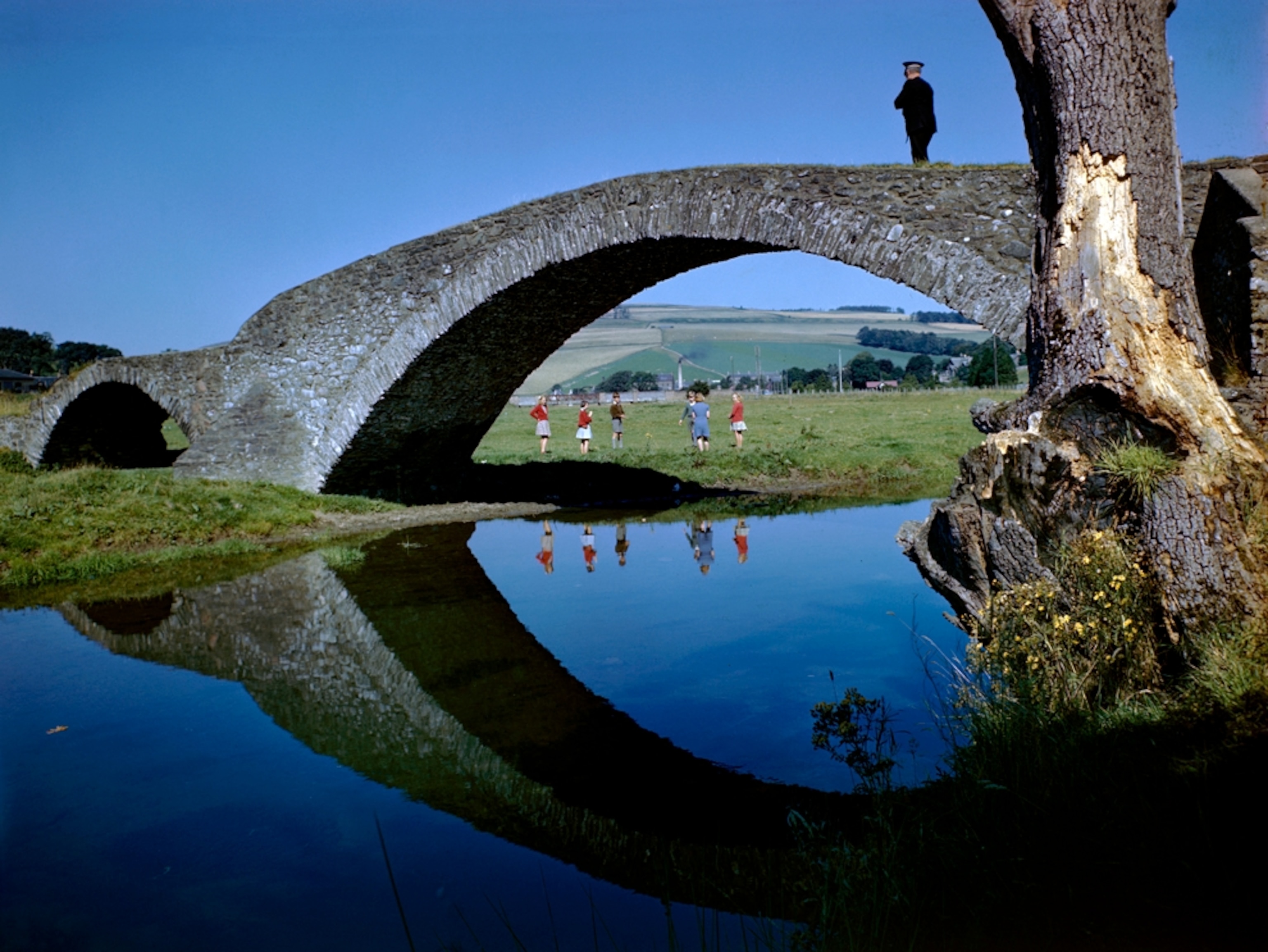 Children playing near a stone bridge