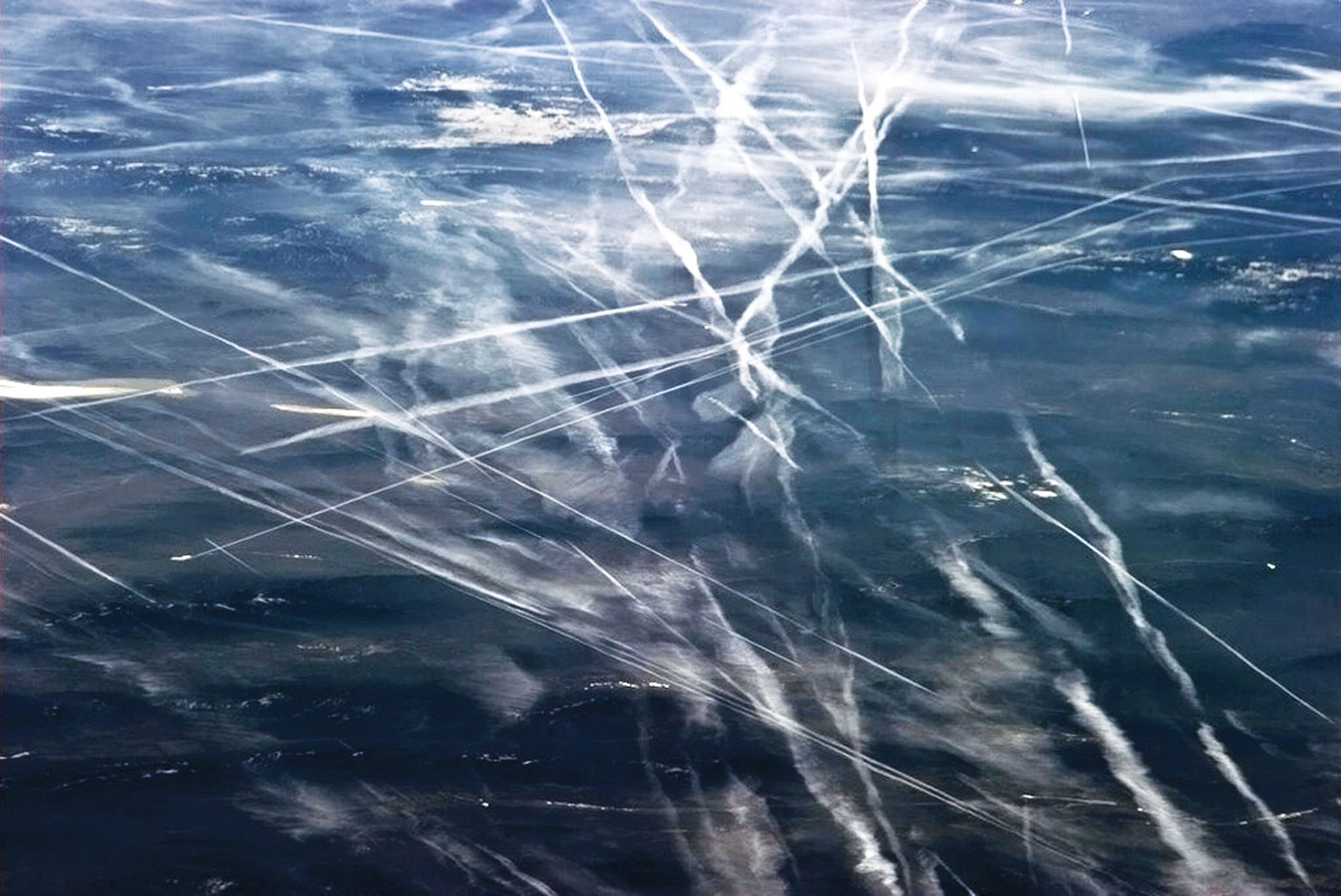 contrails produced by aircraft over the ocean.