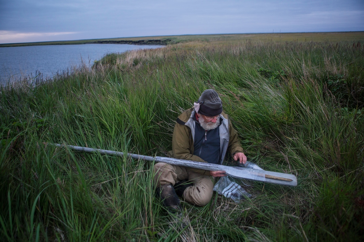 Picture of man wrapping with plastic the wooden bow on the oar.