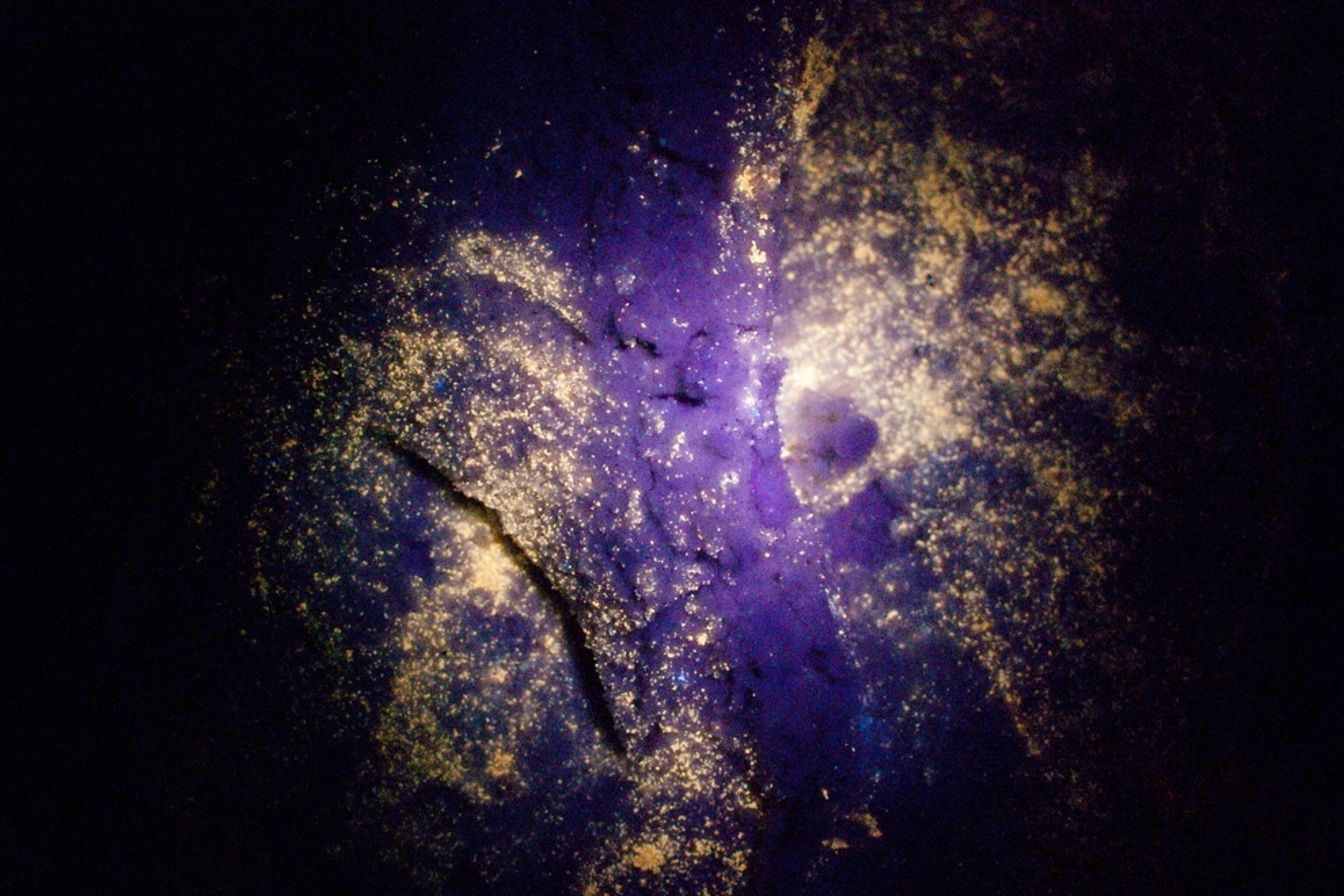 footprints contaminated by oil from the Gulf spill on the beach under ultraviolet light.