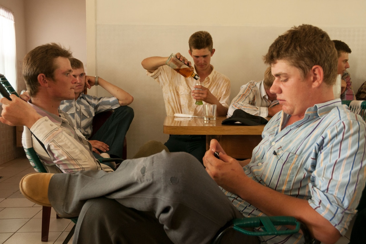A group of young men socialize on Sunday. It is forbidden to drink alcohol but the young people do so when the parents are not there. Since the baptism age is between 20 to 24, this behavior is tolerated. After baptism however, this would lead to expulsion from the colony. The Manitoba Colony, Bolivia. 2008