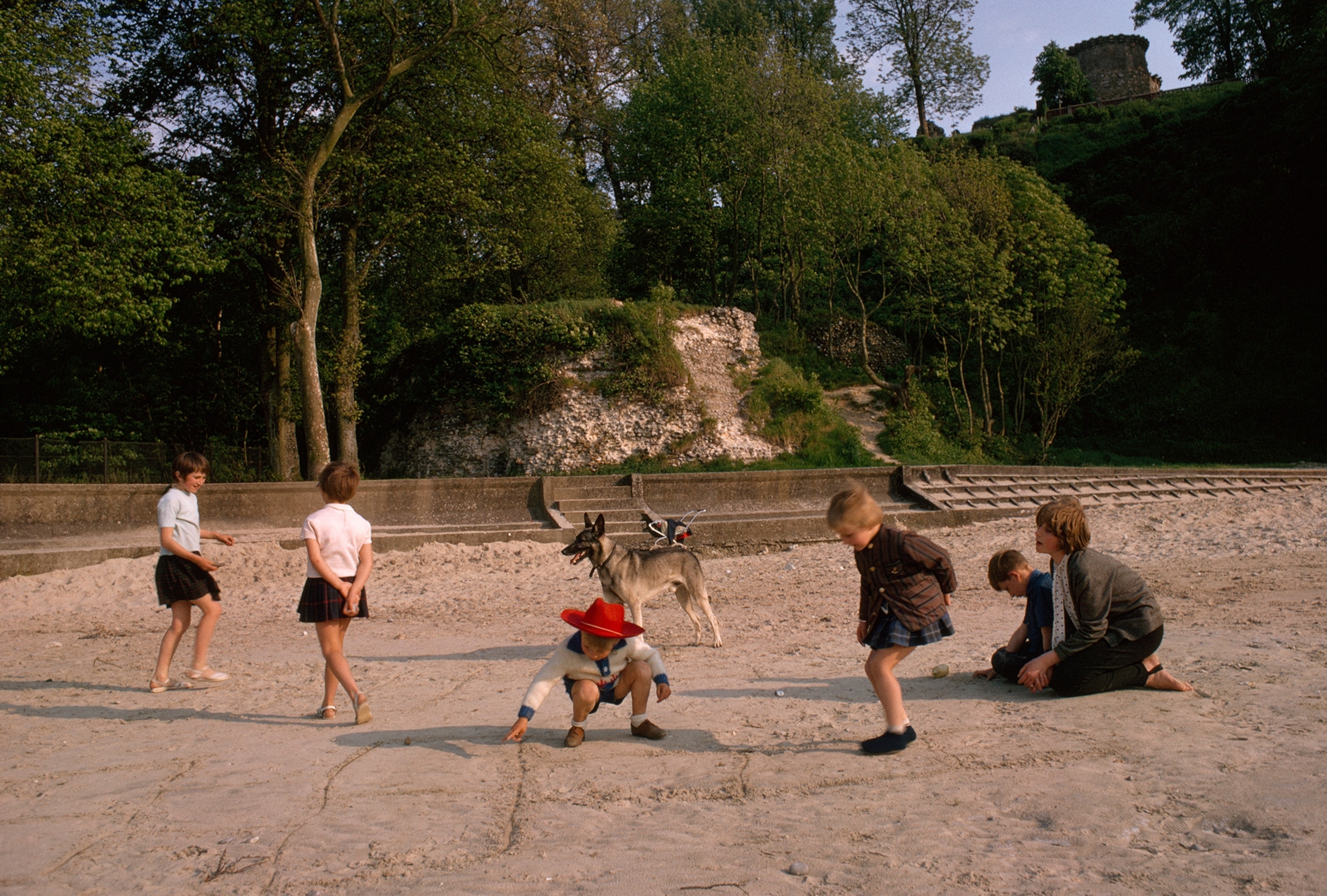Children play hopscotch in front of ruins of Harold's Tower.