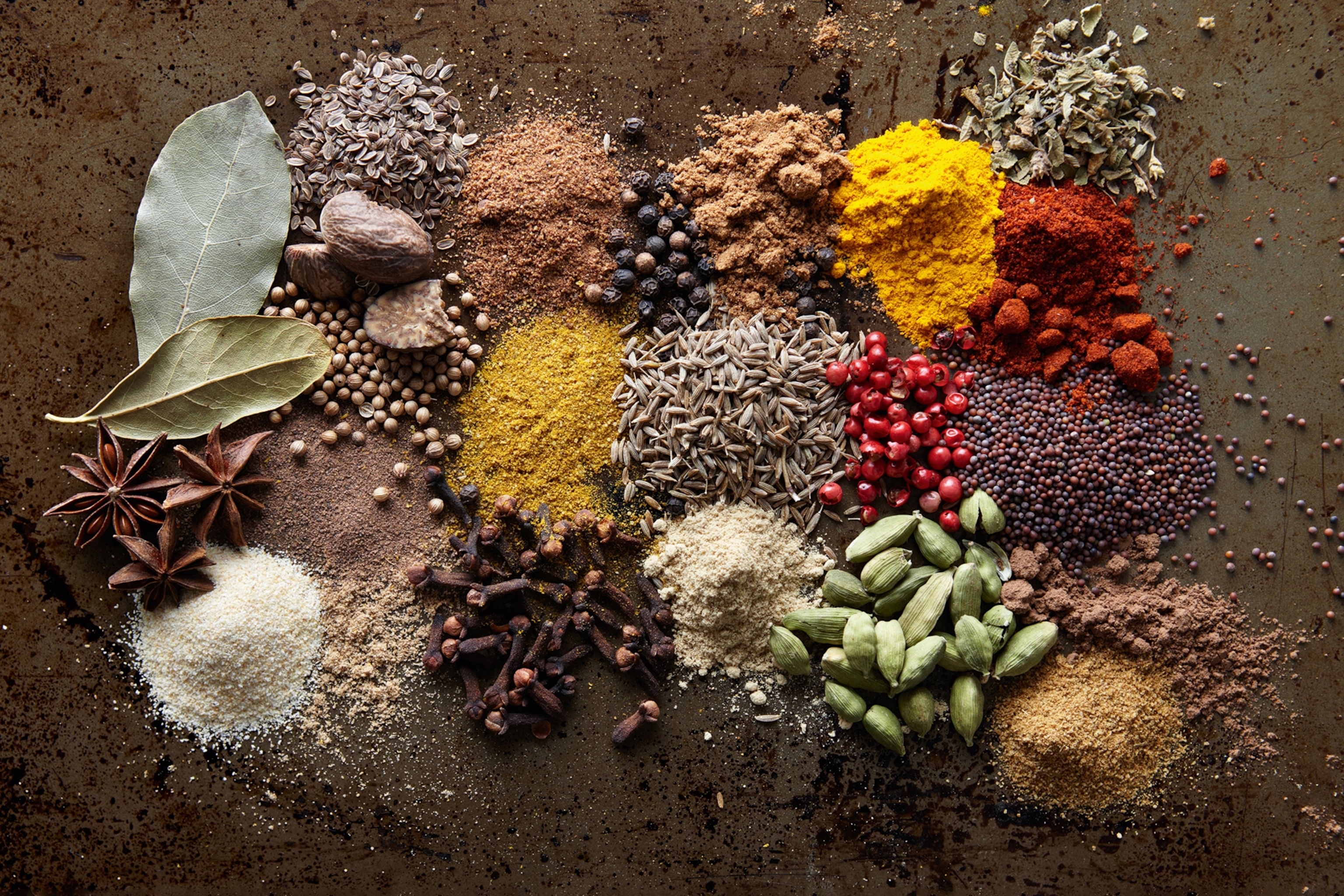 Small piles of different spices arranged like a colour palette.