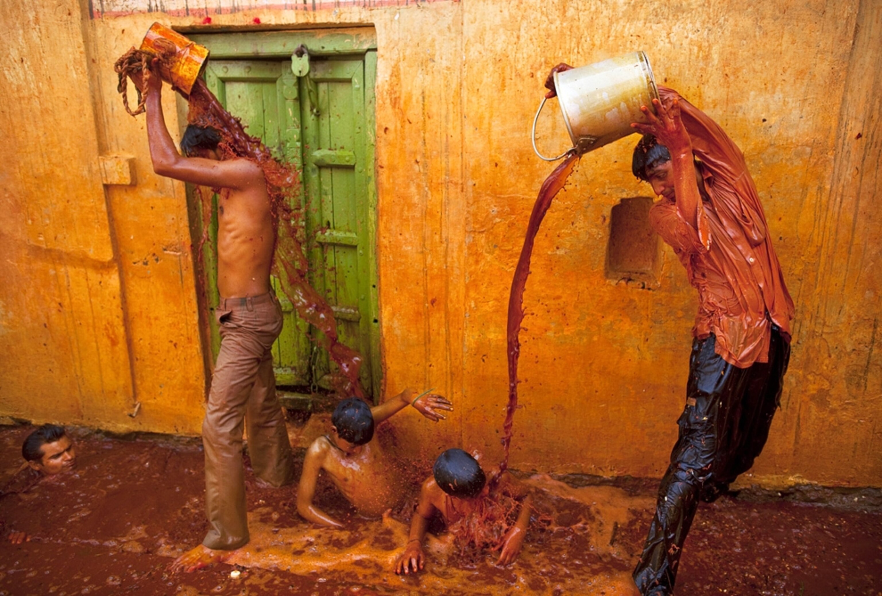 Holi festival picture: people celebrating with buckets of dyed water