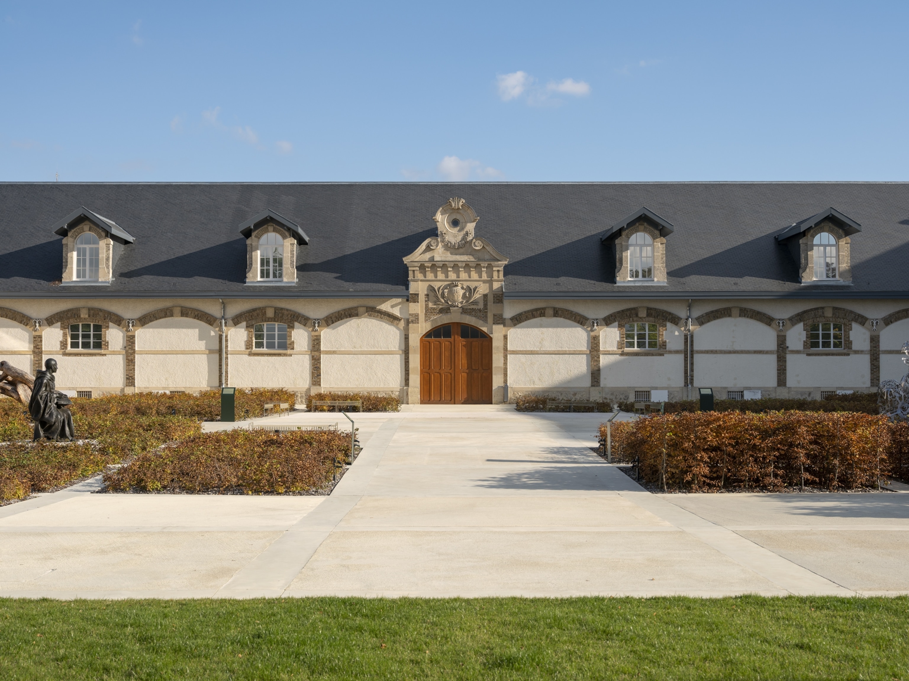 Exterior view of the Ruinart Champagne building at 4 rue des Crayères in Reims, France, with the building set against a clear blue sky.
