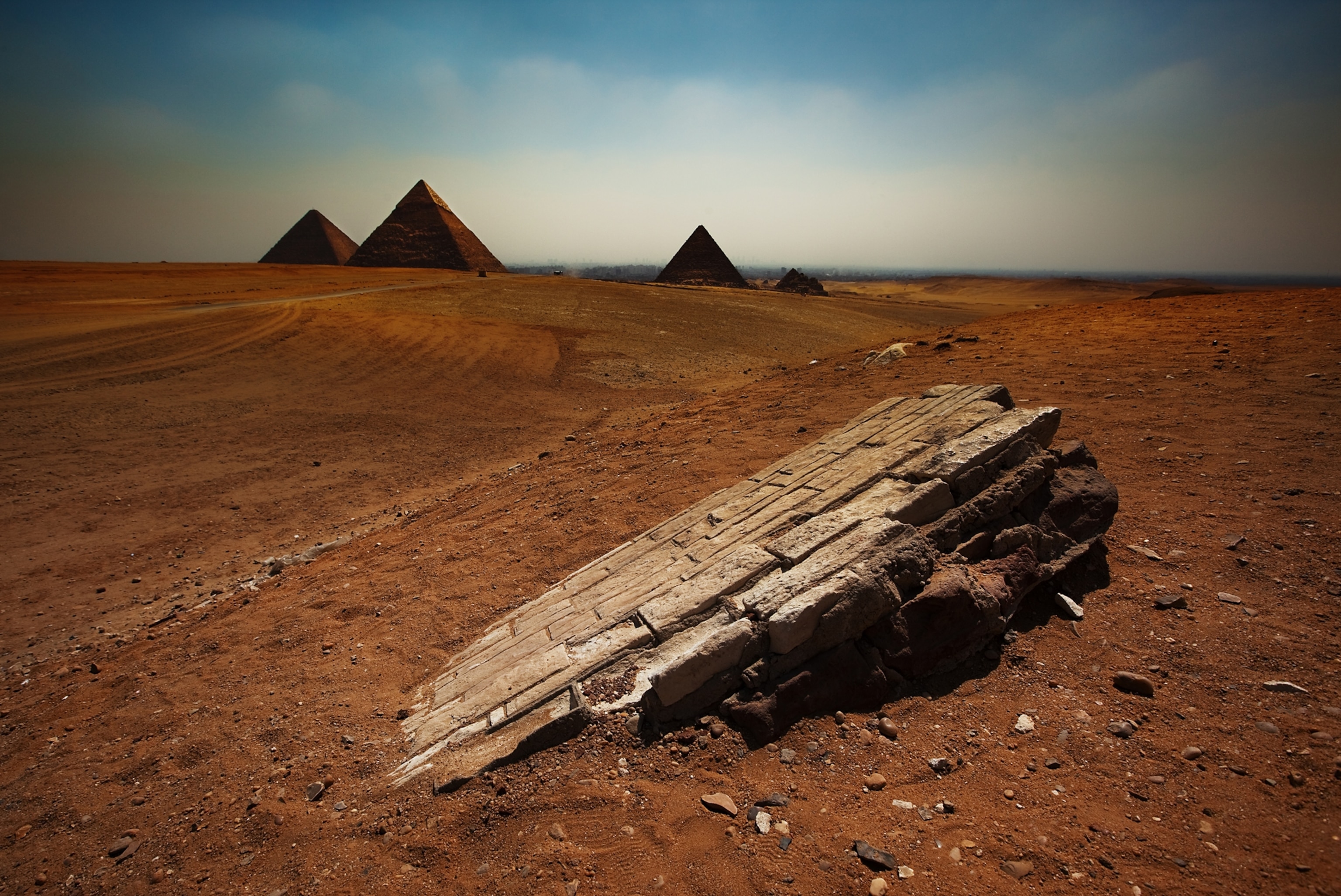 An up-close image of one of the pieces of the pyramids in the desert. In the background there are pyramids.