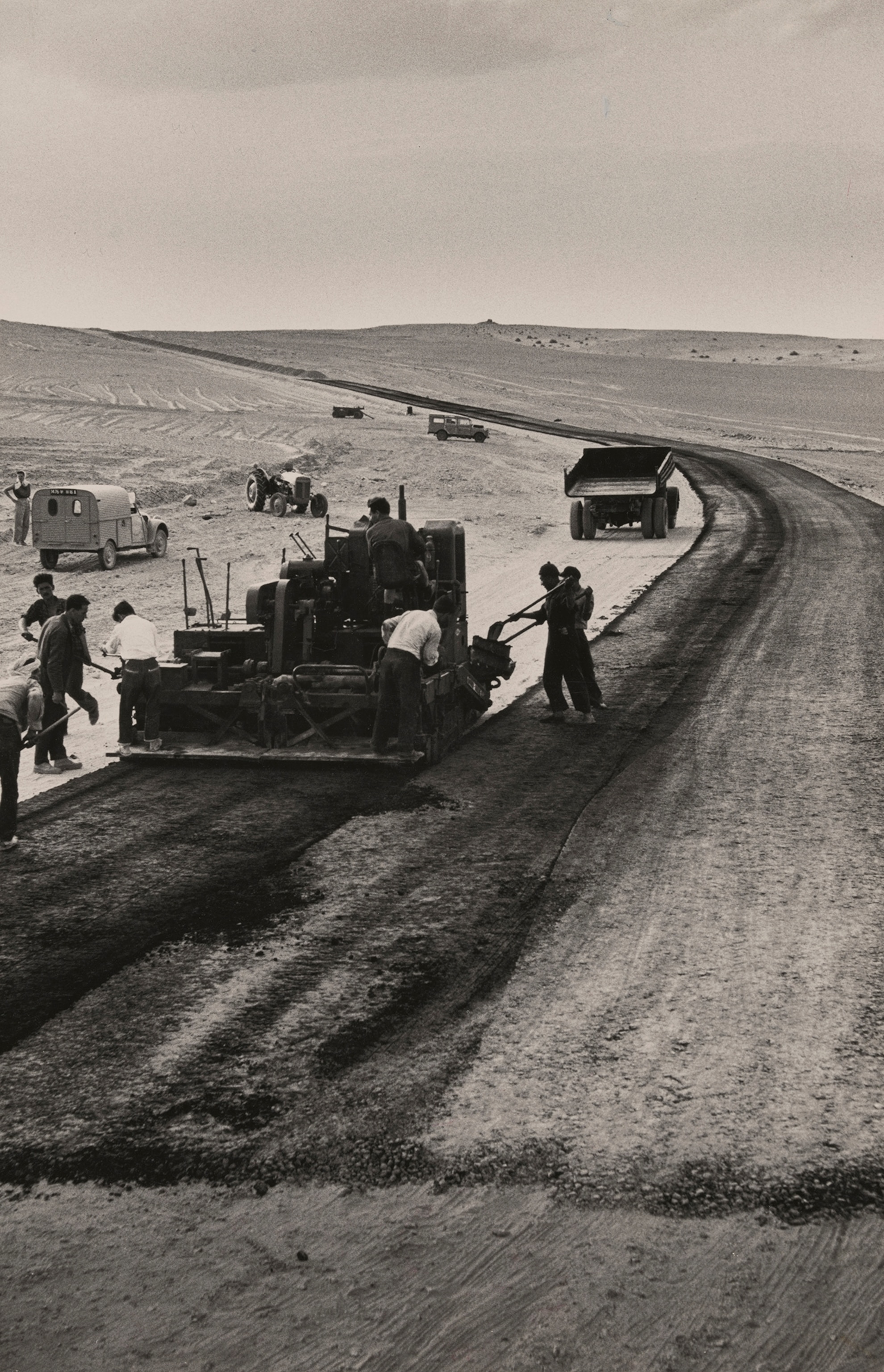A crew lays special heat-resistant asphalt for a 26-foot-wide, 185-mile-long road in the desert.