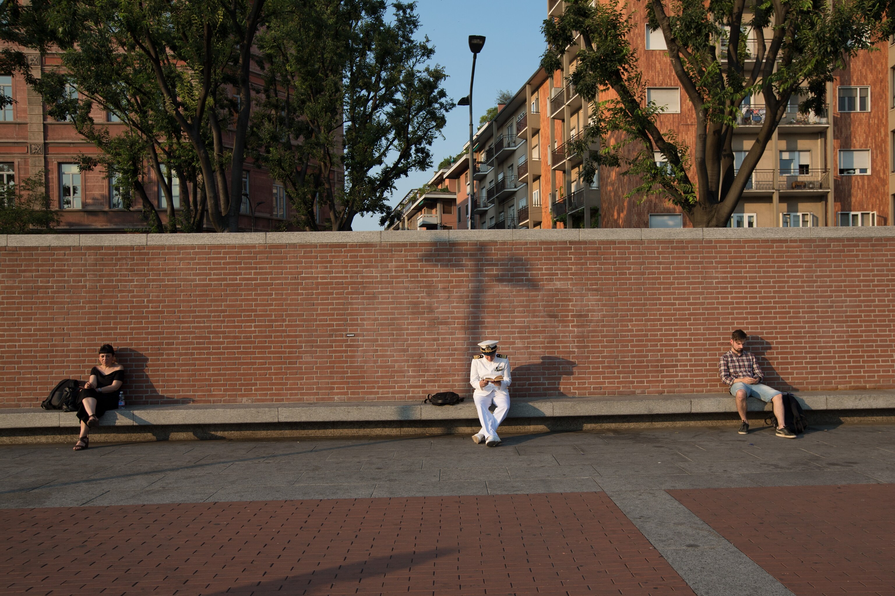 people sitting on the bank of the Darsena in Milan, Italy