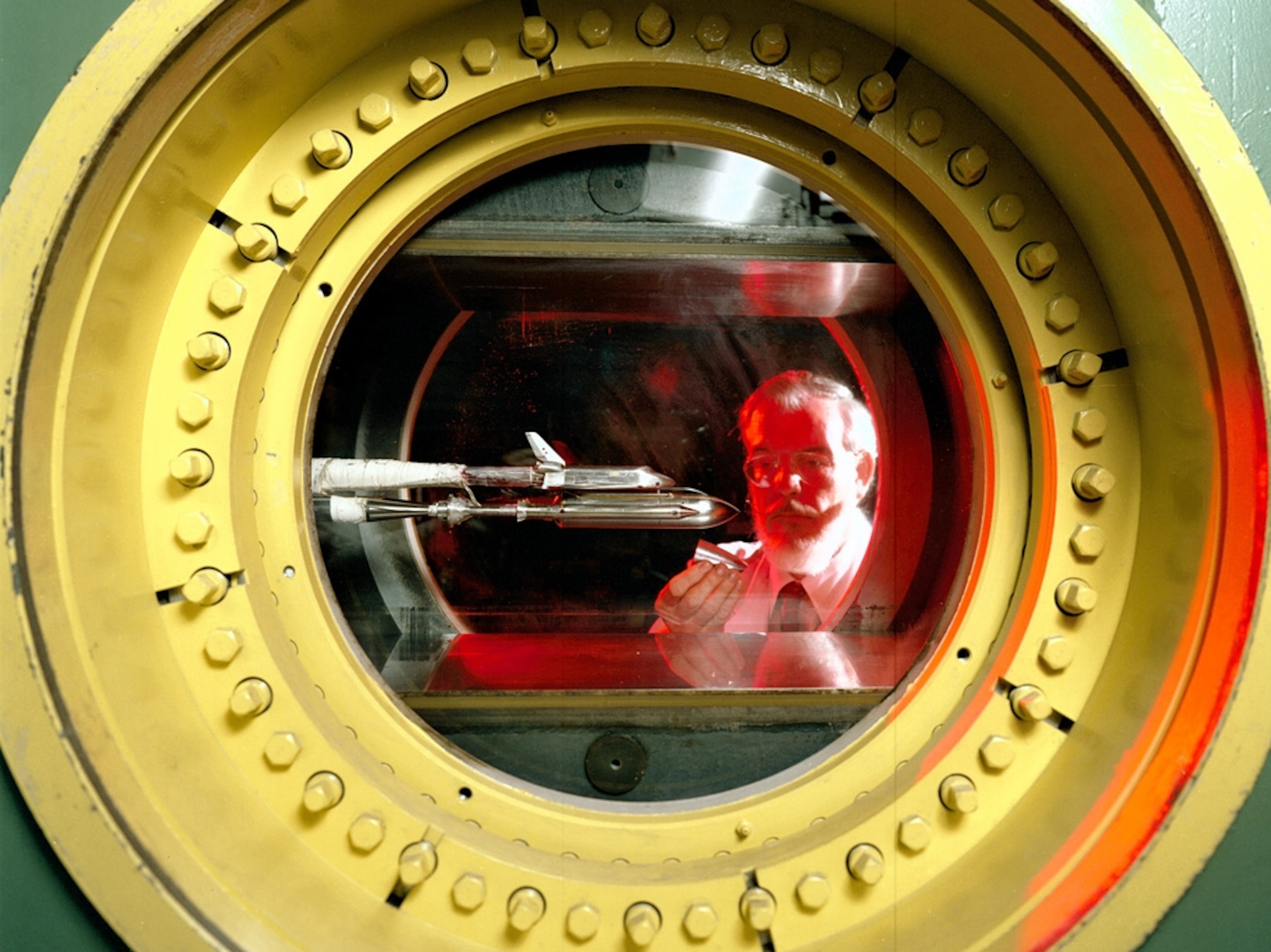 NASA rocket picture: an engineer looking at a space shuttle model in a wind tunnel