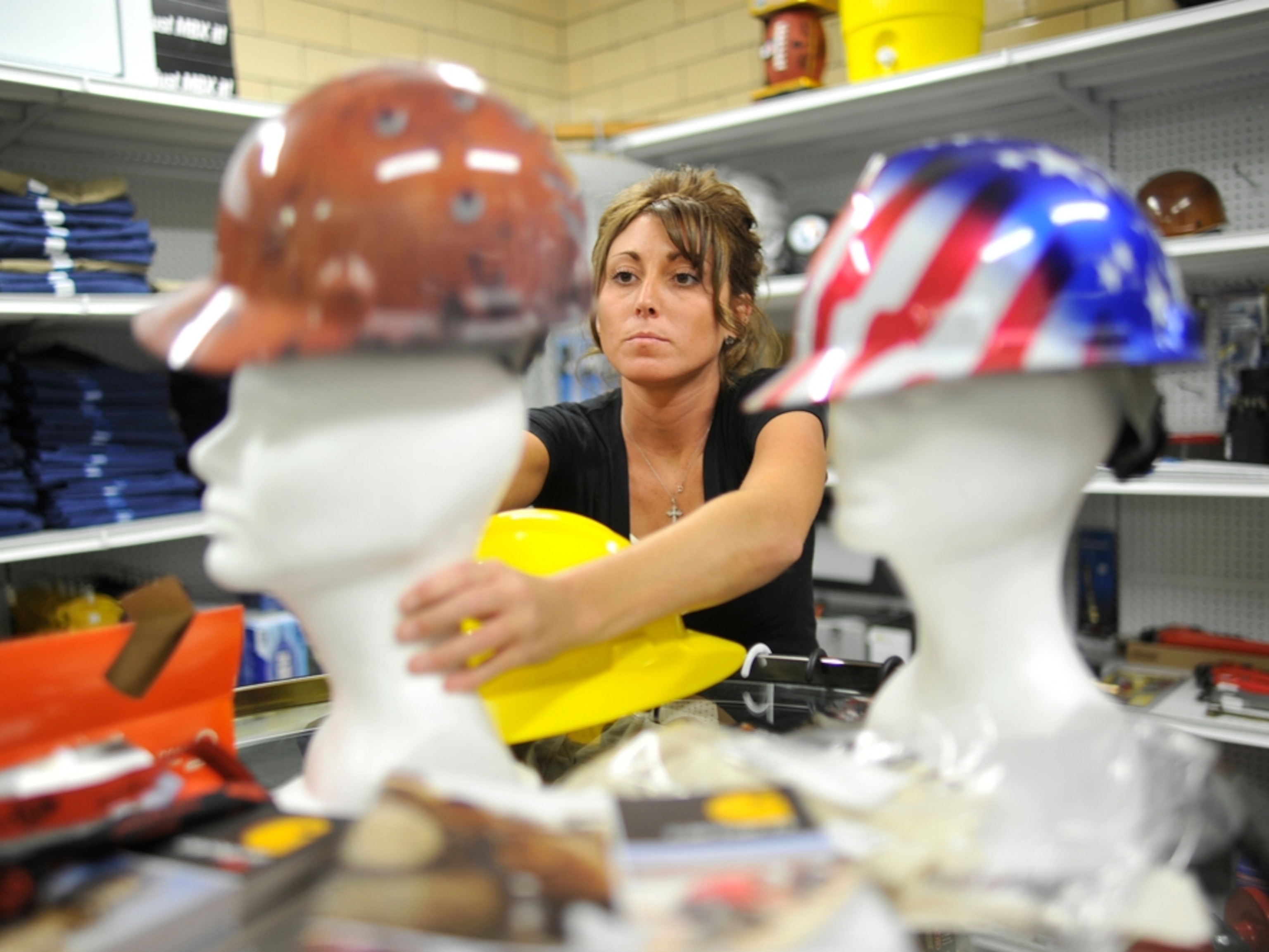 Employee Samantha Salata adjusts a hard hat display in a store that sells supplies related to the natural gas industry.