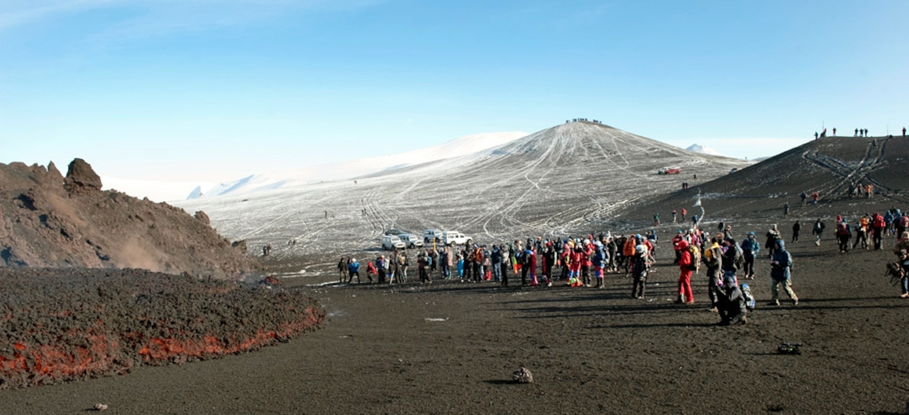 Picture of a line of tourists forming near a cooling lava flow near Iceland's Eyjafjallajökull volcano.