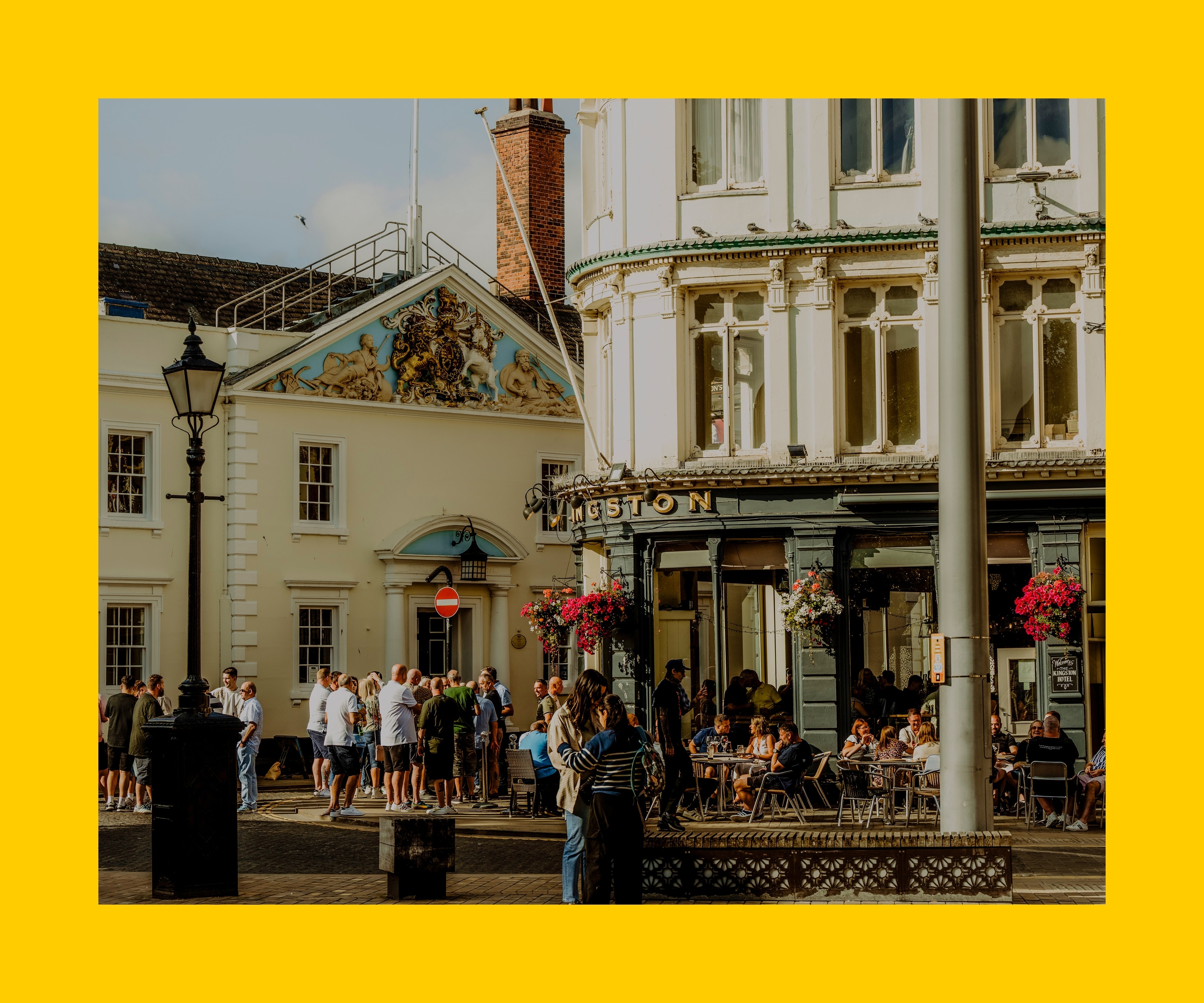 A scene from Hull’s maritime heritage and community, showing a view down North Church Side with a crowd gathered outside the Kingston pub.