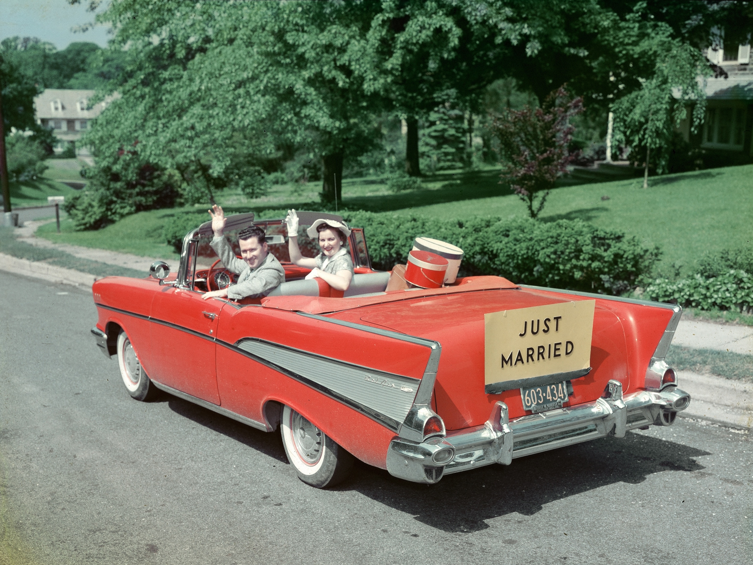 Newlyweds wave from Chevrolet Bel Air