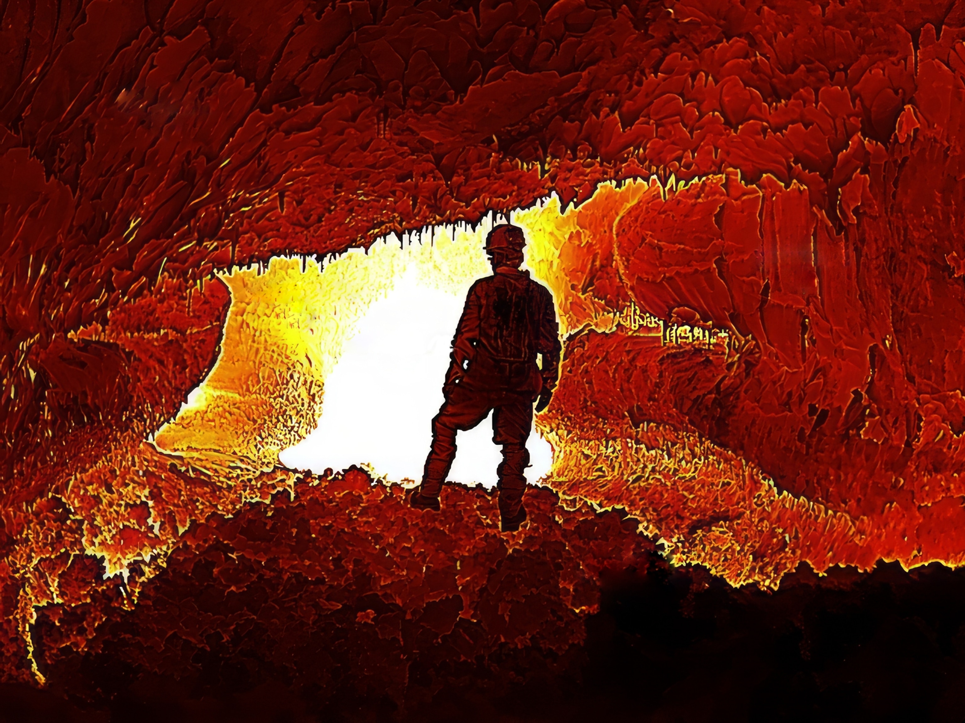 A thermal view within a lava tube; the dark figure of a researcher is relatively cool compared to the bright red, orange, and white colors of the tube walls and ceiling that reveal how quickly temperatures sore in the lava tubes.