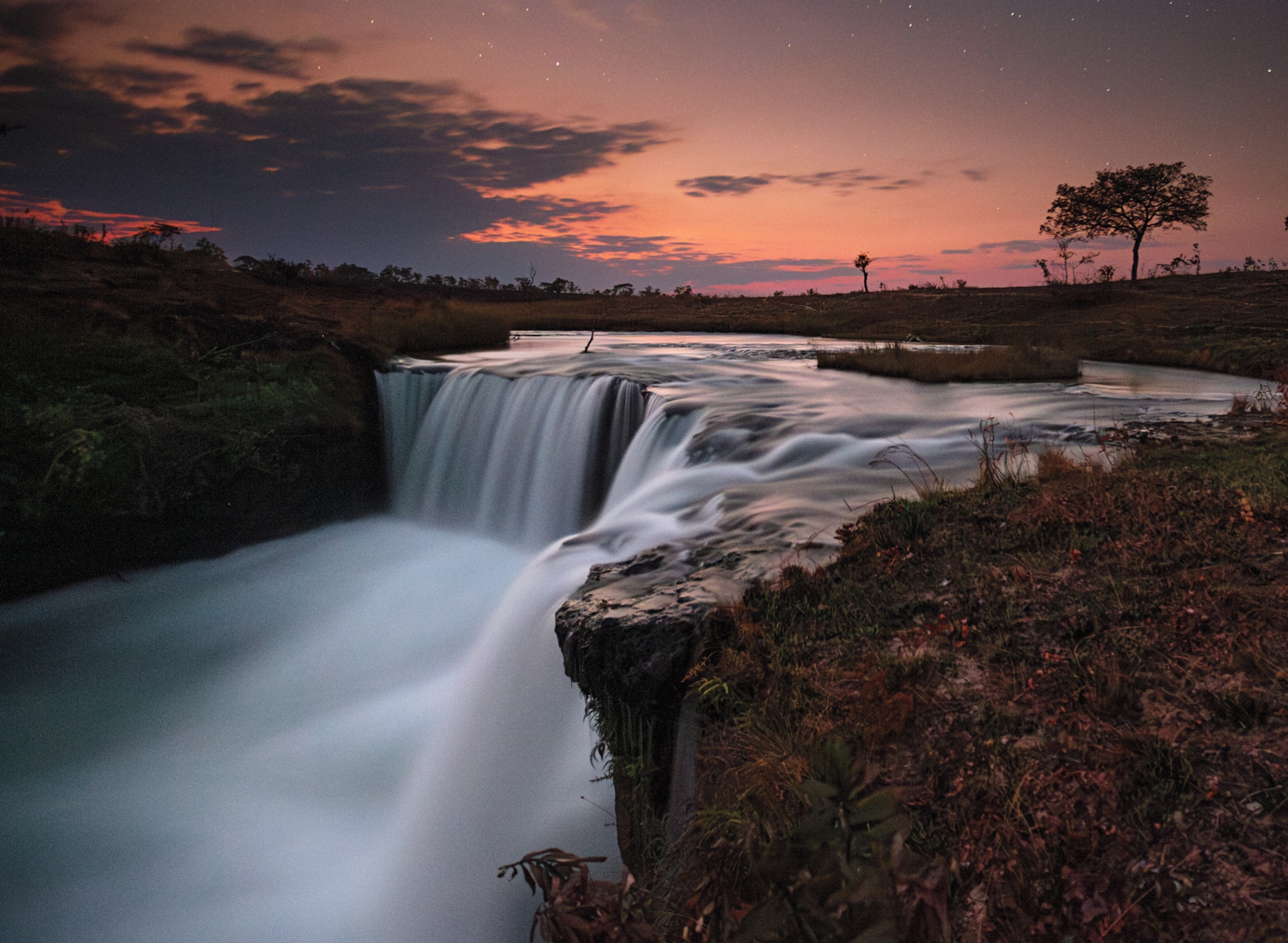 Water in the waterfall looks white in the sunset light.
