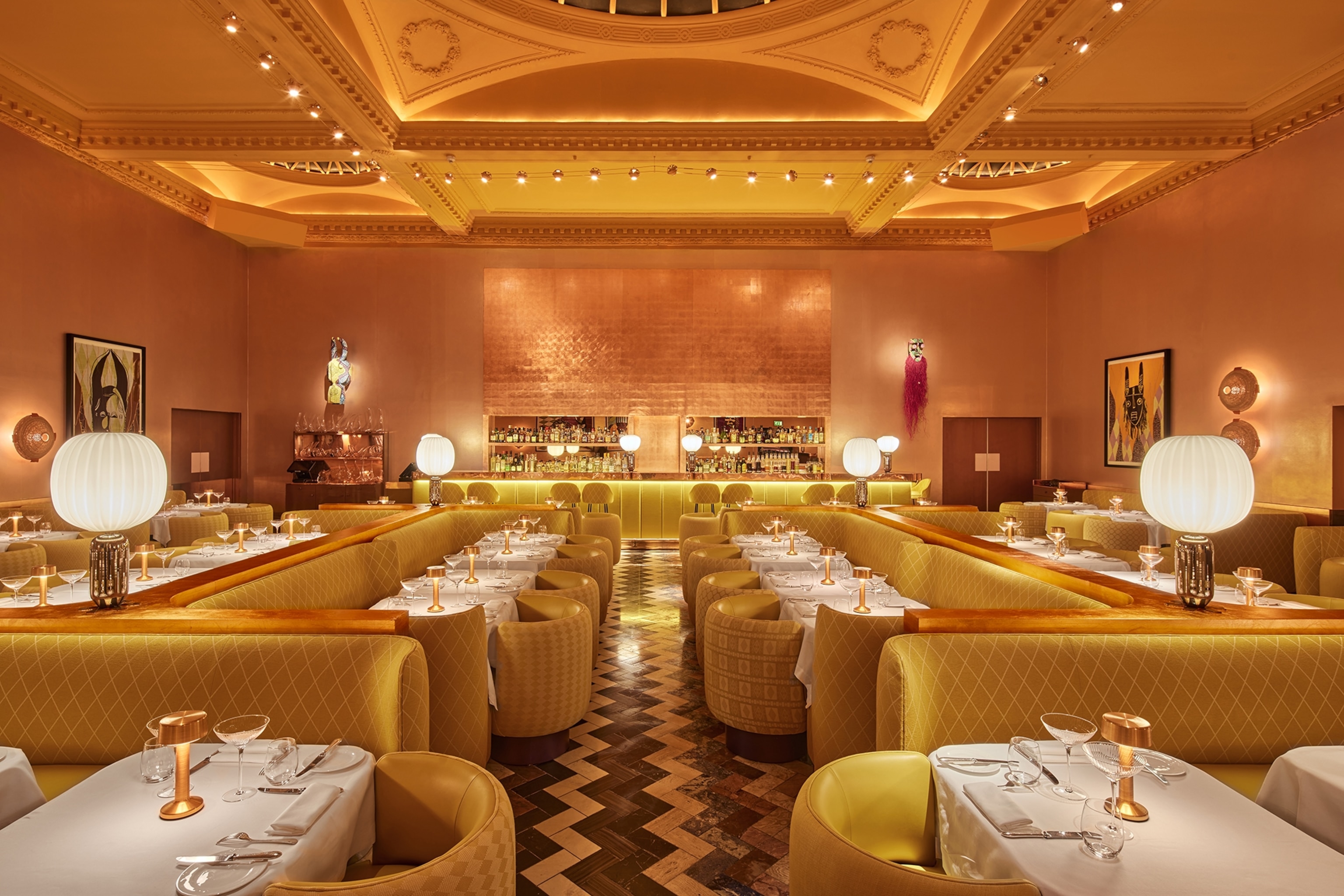 A luxurious and quirky bar with low booths of cushioned benches and arm chairs.