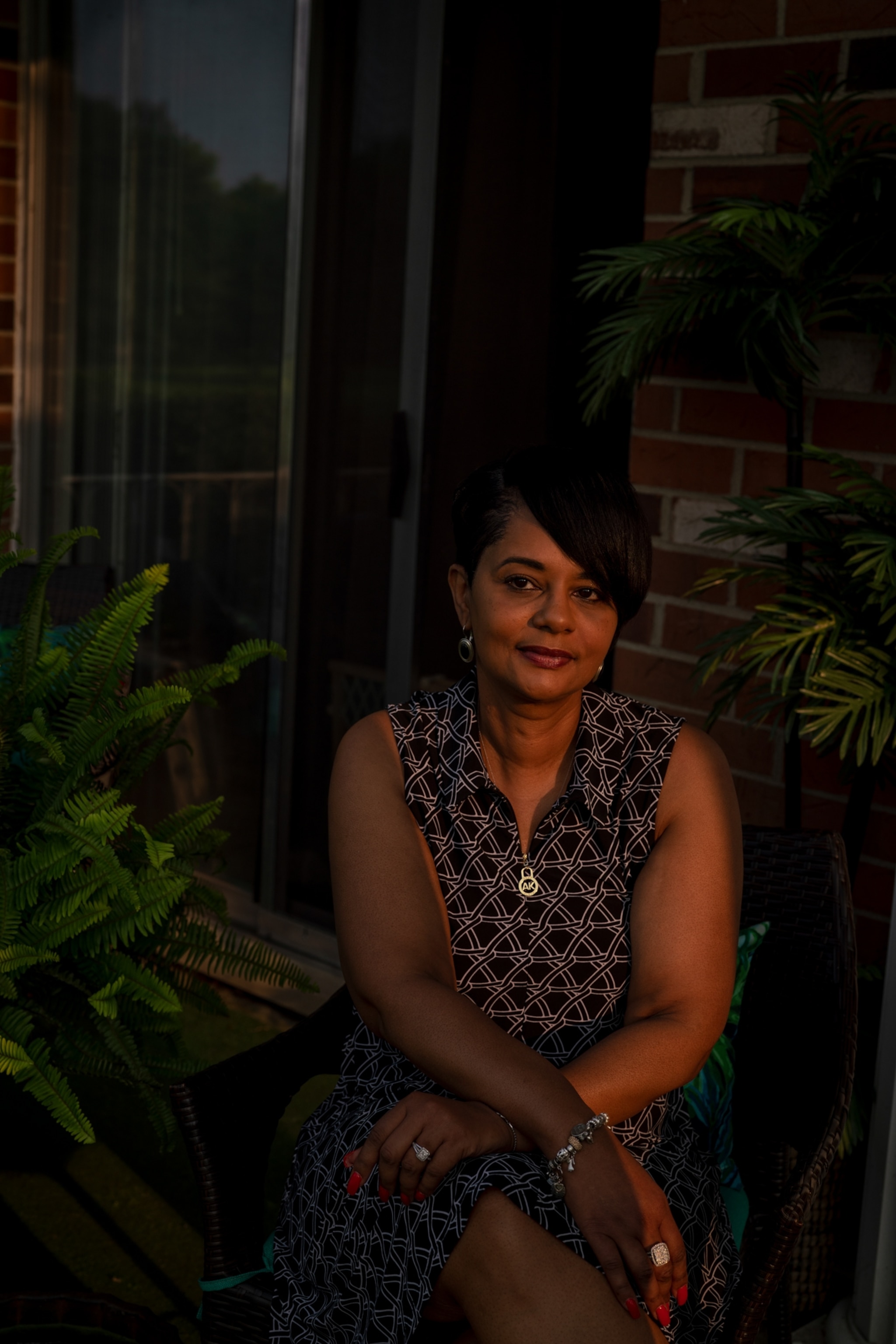 a woman poses for a portrait outside her home