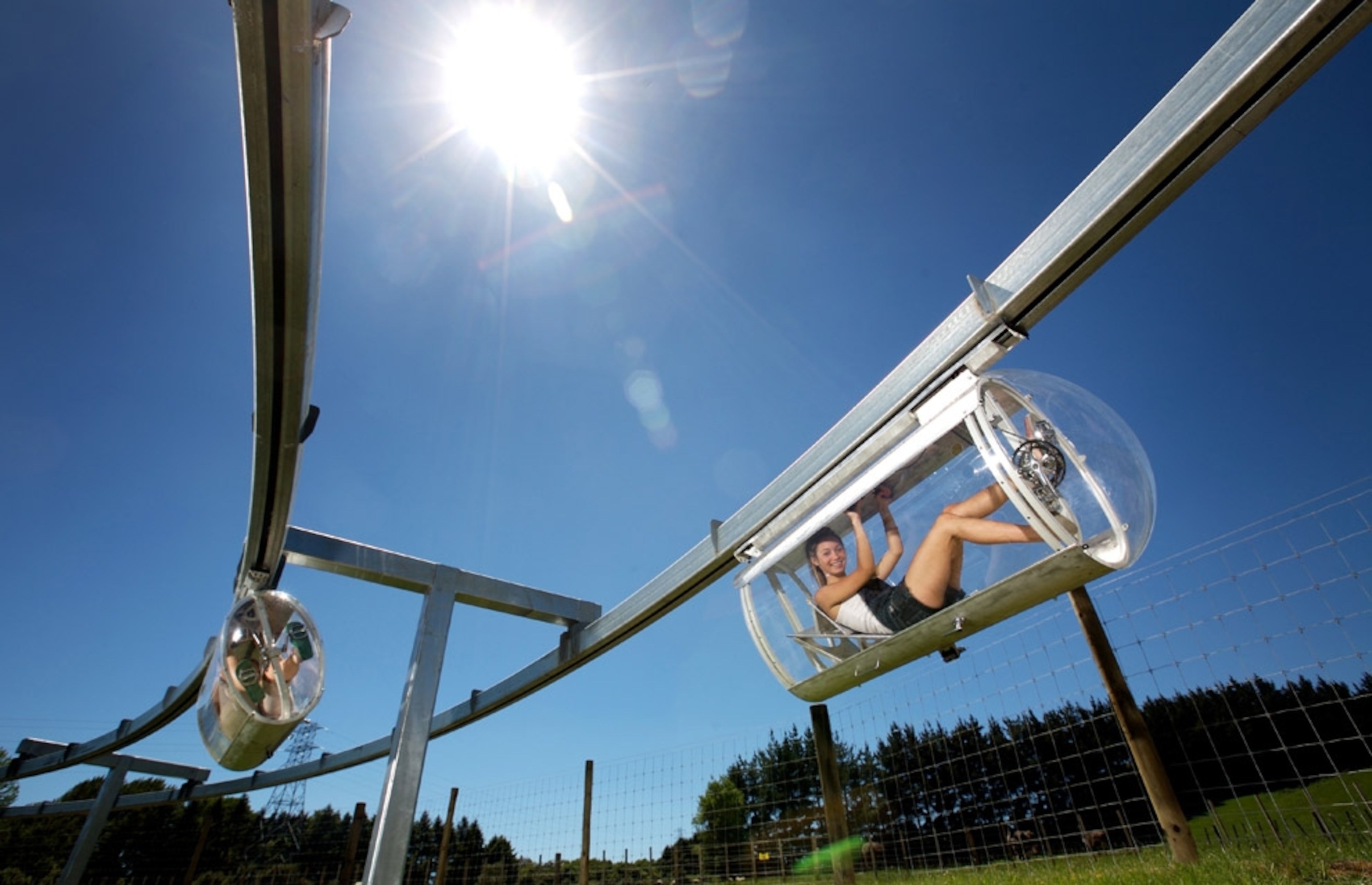 People riding in Shweeb Monorail in Rotorua, New Zealand