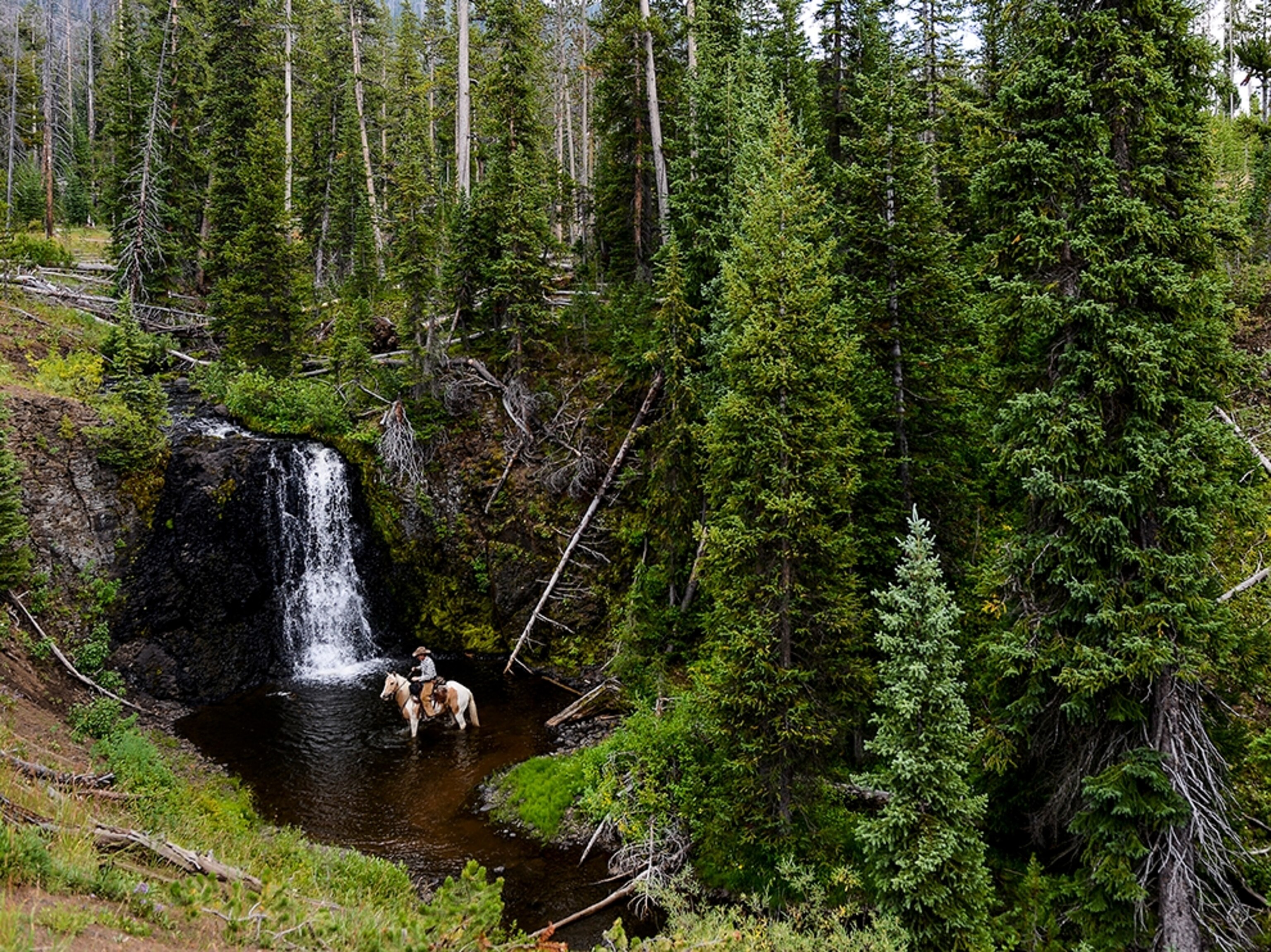Ben Masters exploring a waterfall with his horse.