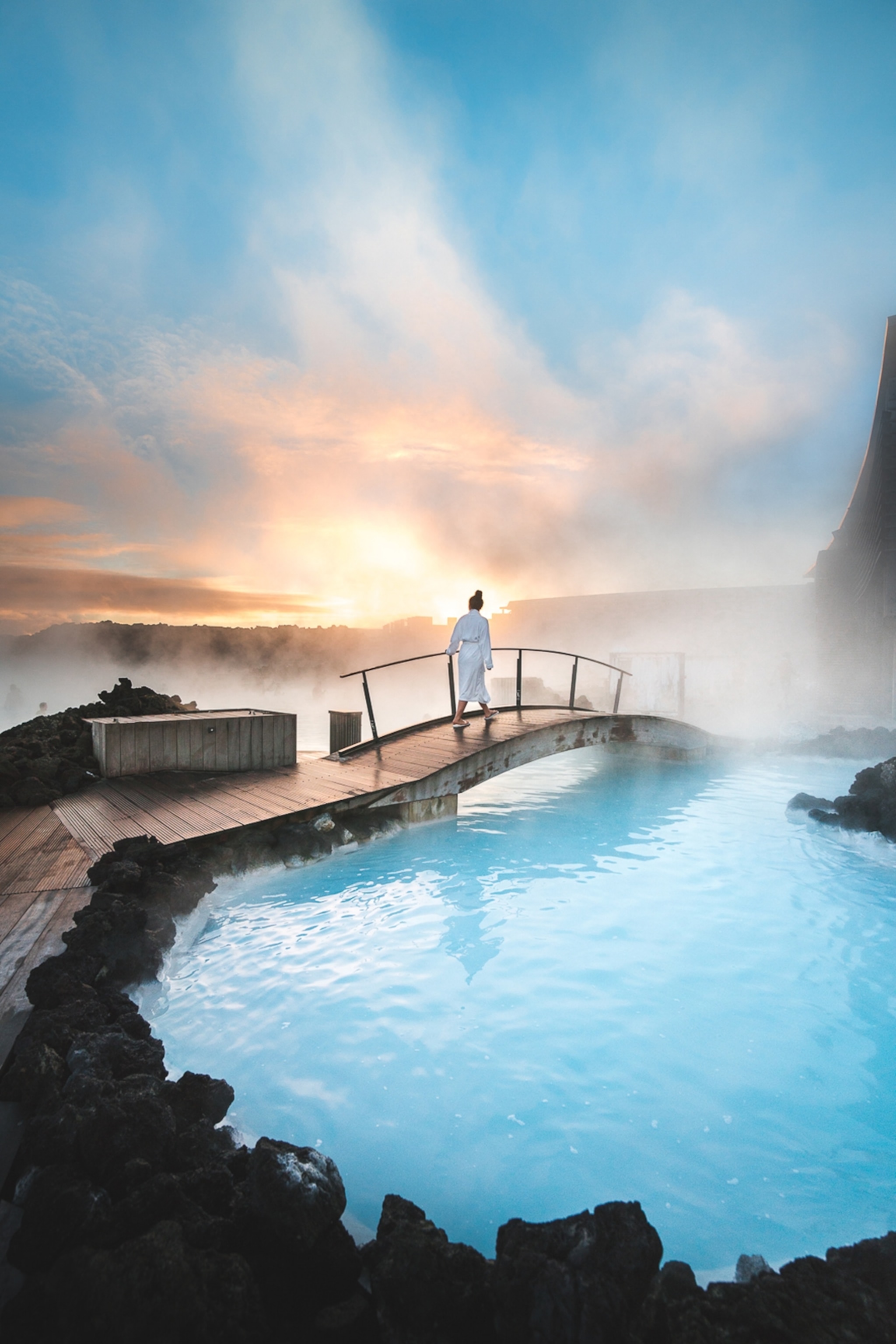 Woman standing on bridge between two pools
