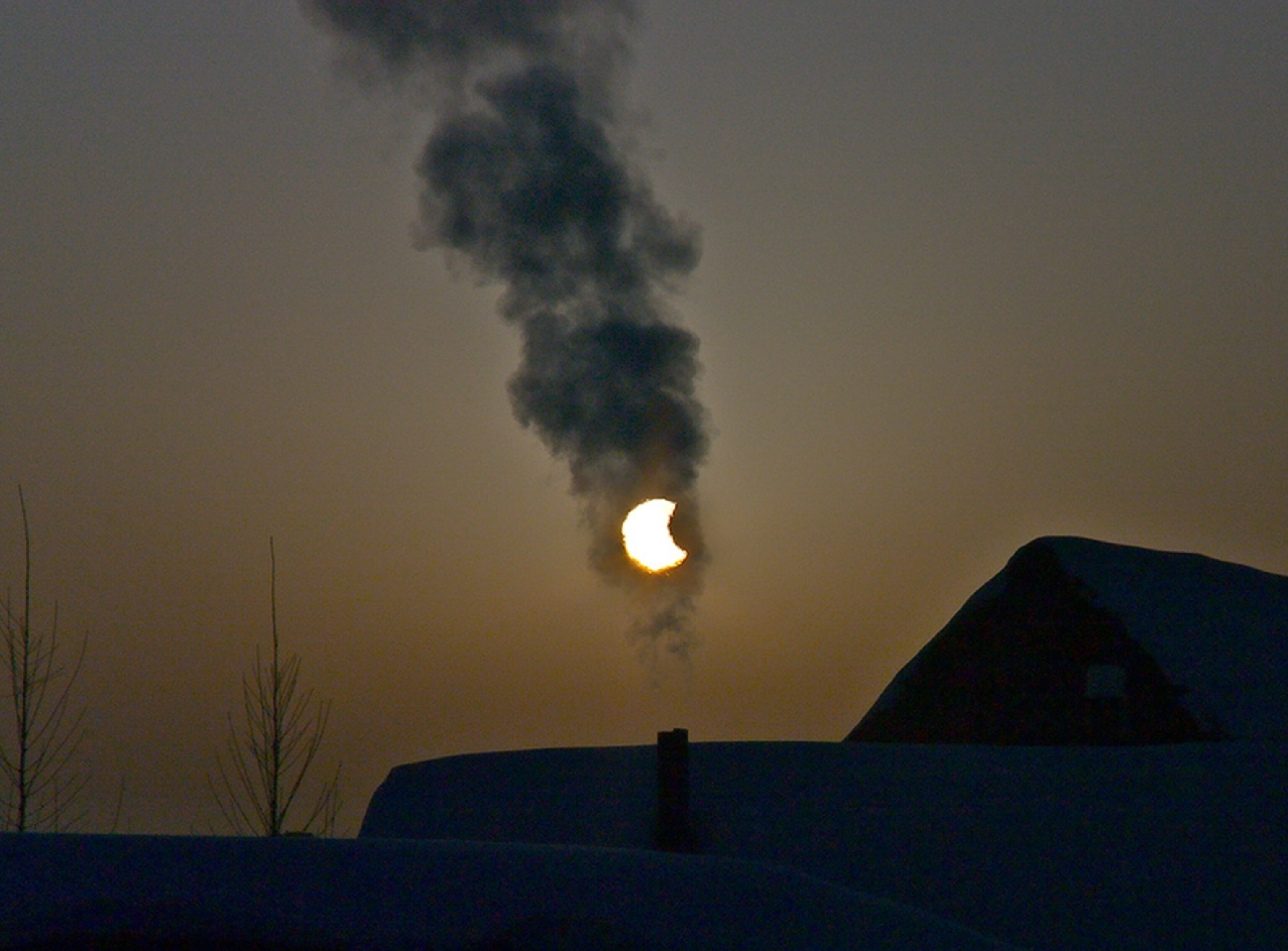 A partial solar eclipse seen through chimney smoke in Siberia (picture).